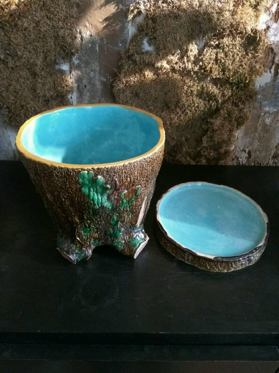 This planter imitates a tree stump. Its centre is enameled with a luminous blue which is a characteristic of the English manufacture. This color serves as a signature and brings a very decorative touch to the piece The subject of the tree stump was