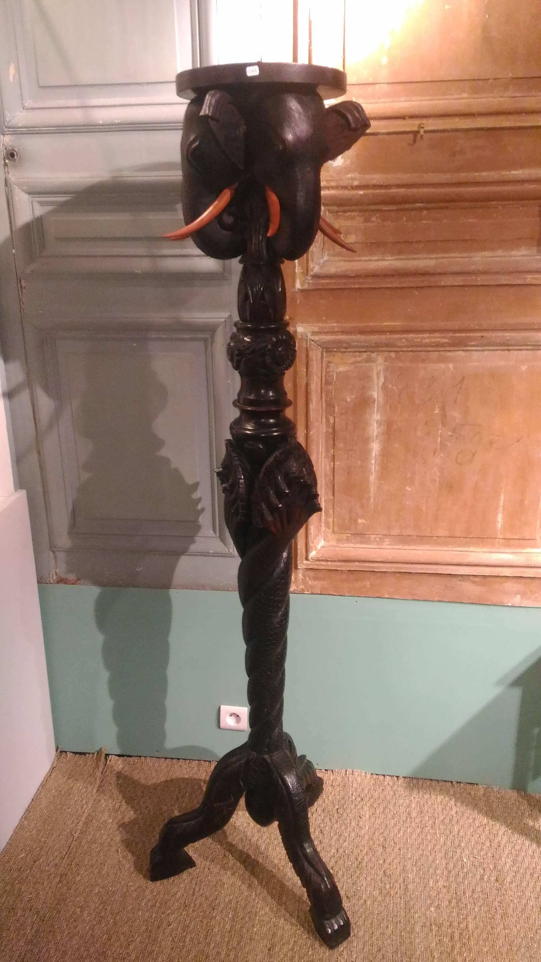 This pedestal dates from the late 19th century. It consists of a long barrel ending in 3 feet of animals reminiscent of a griffin. The column, stylized, is formed by reptile tails joining at the first level of the pedestal. The underside of the