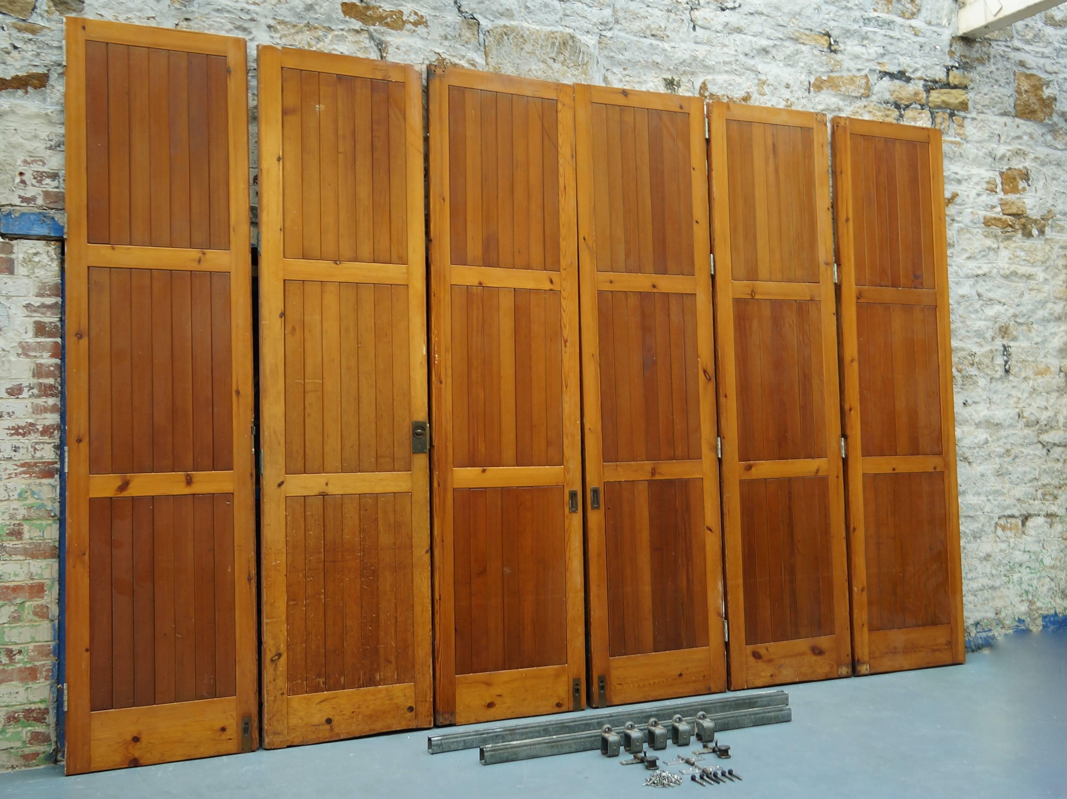 An amazing set of six rare 1960s reclaimed / salvaged solid oregon pine room dividers / hinged bi-folding doors.

These used to partition off a large hall space when needed with the option of using a fixed single door as access when closed.