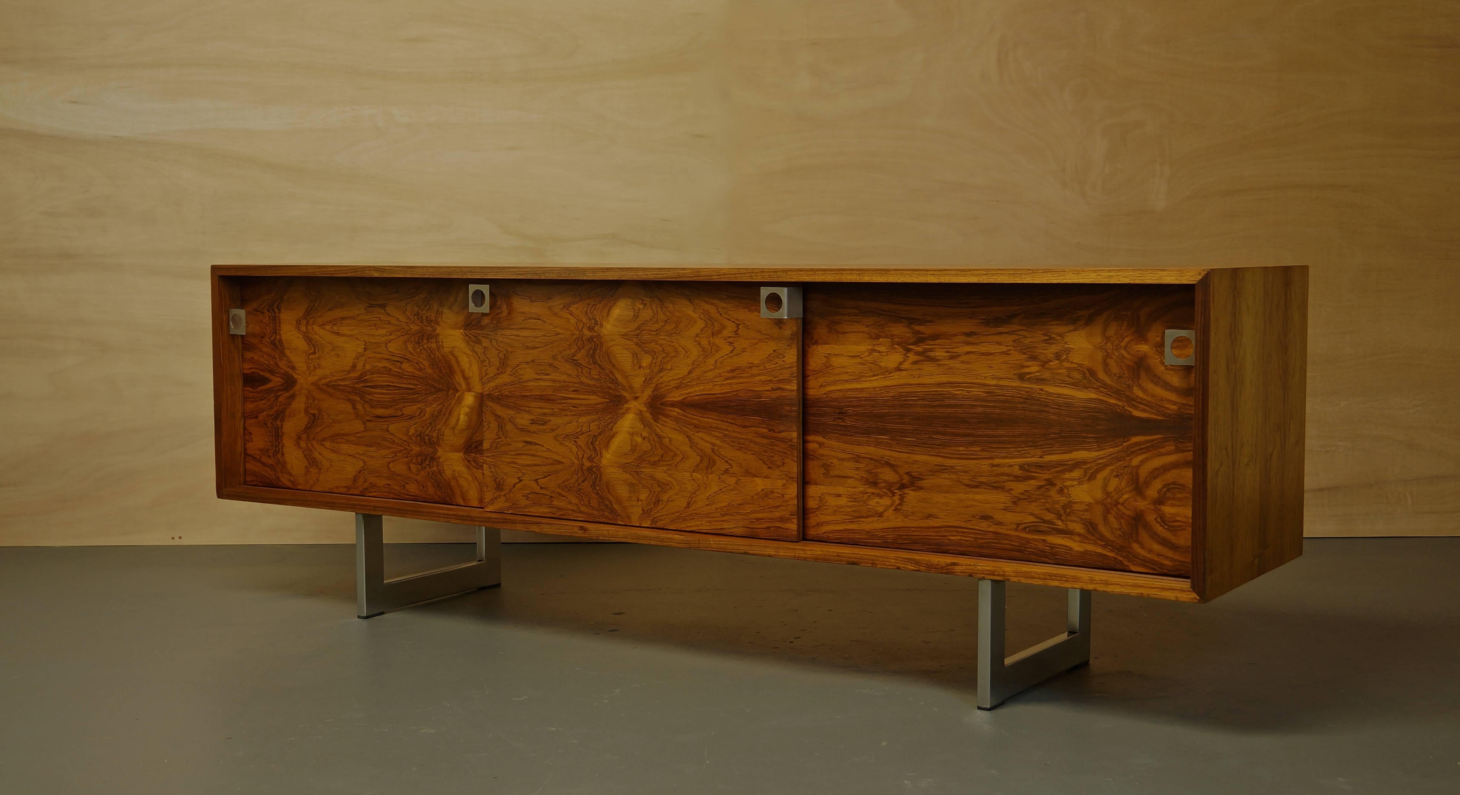 Rare Danish rosewood sideboard or Credenza by Bodil Kjaer. 

A beautiful rosewood storage cabinet with incredible natural grains.

This rare model features three sliding doors with steel handles.

Designed in 1959 and produced by E. Pedersen
