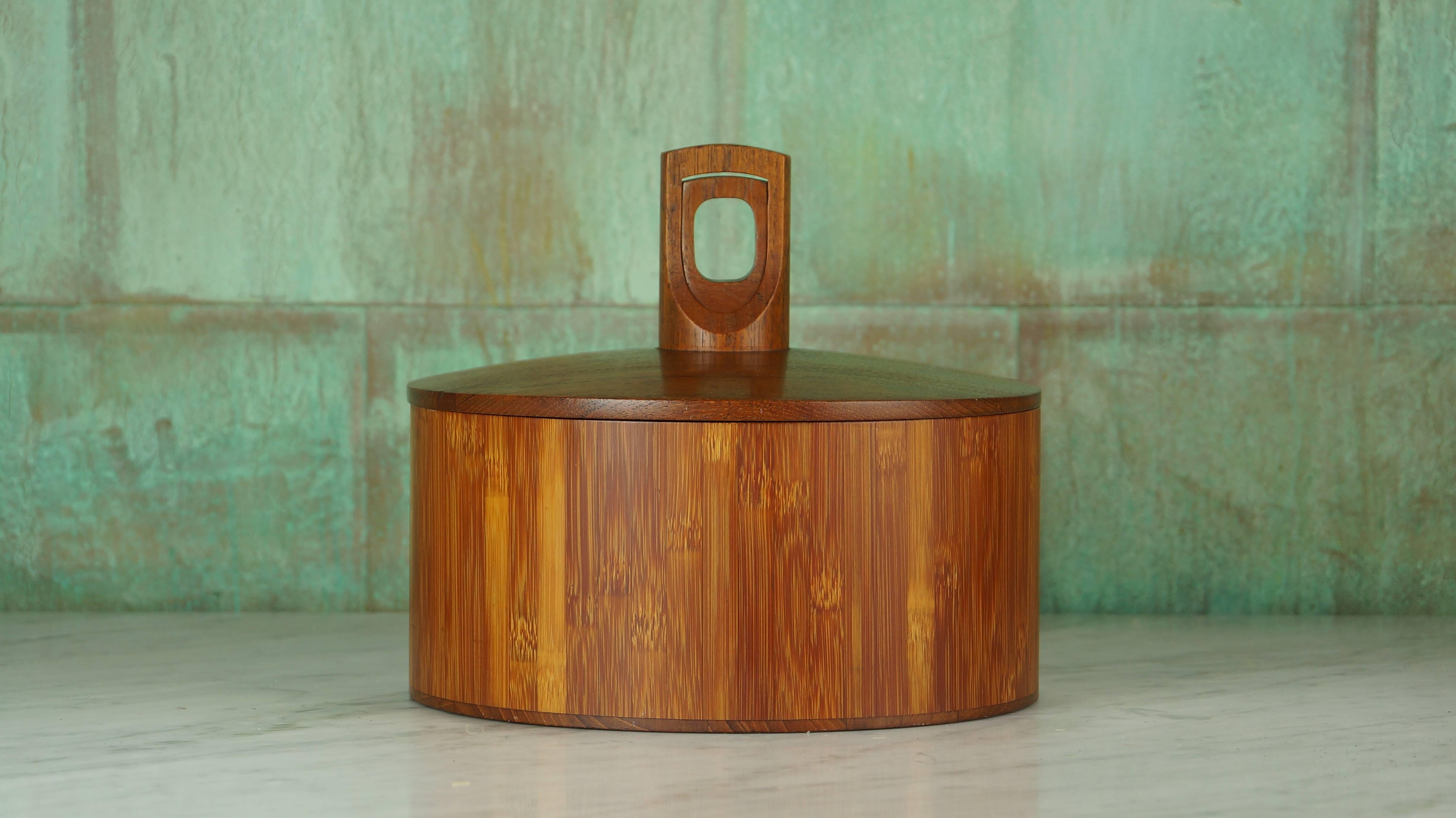 A very rare model 1510 ice bucket from the "Cane And Teak" Collection designed by Jens H. Quistgaard for Dansk Designs. 

With a solid teak lid and handles, a cane/bamboo ice bucket and black plastic liner, this piece is sure to stand out.
