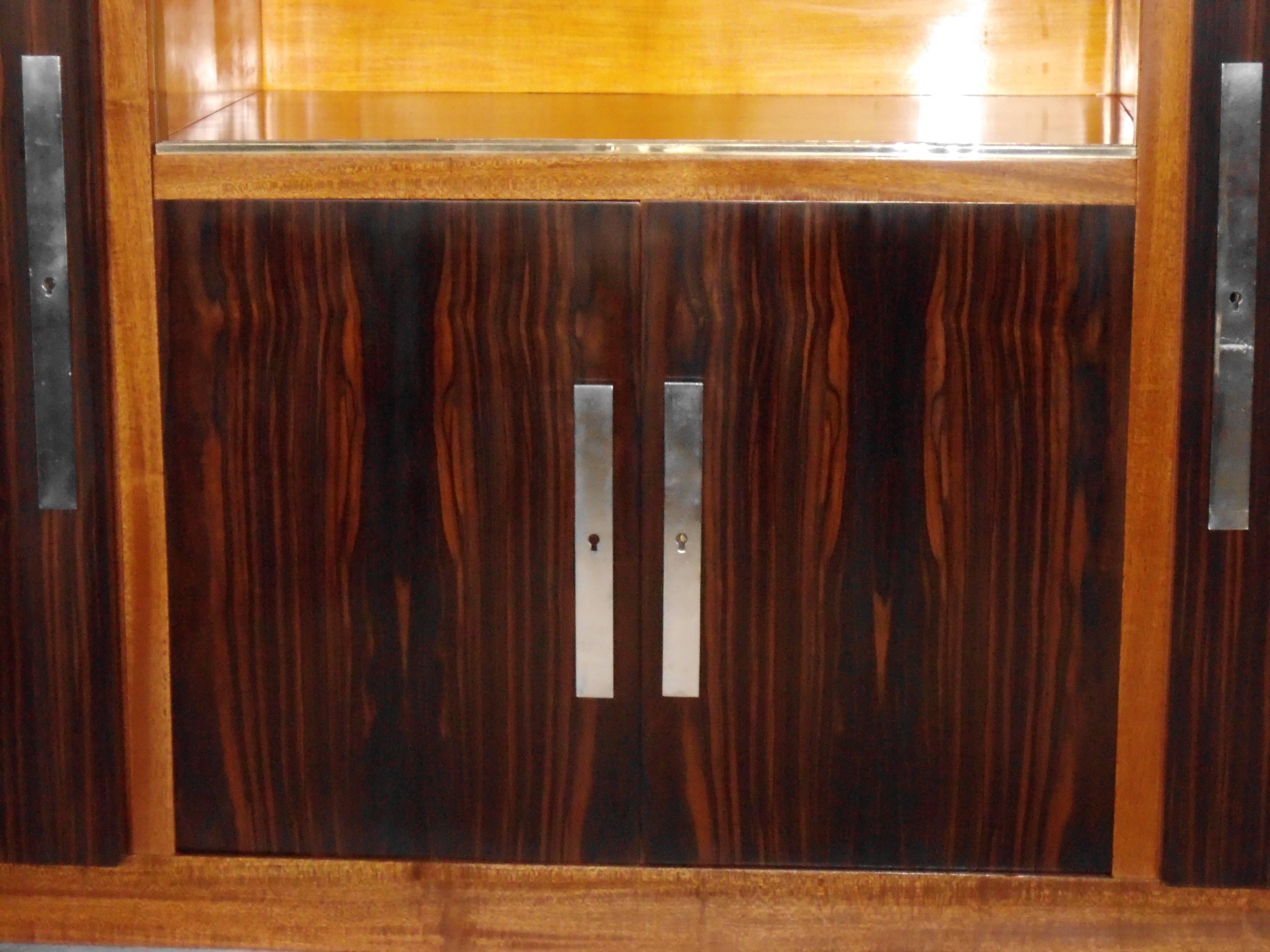 Completely restored Art Deco side board made of full mahogany with ebene de Macassar veneer and green marble top. It can be separated for transport. On each side it has two shelf's and two sliding glass doors.