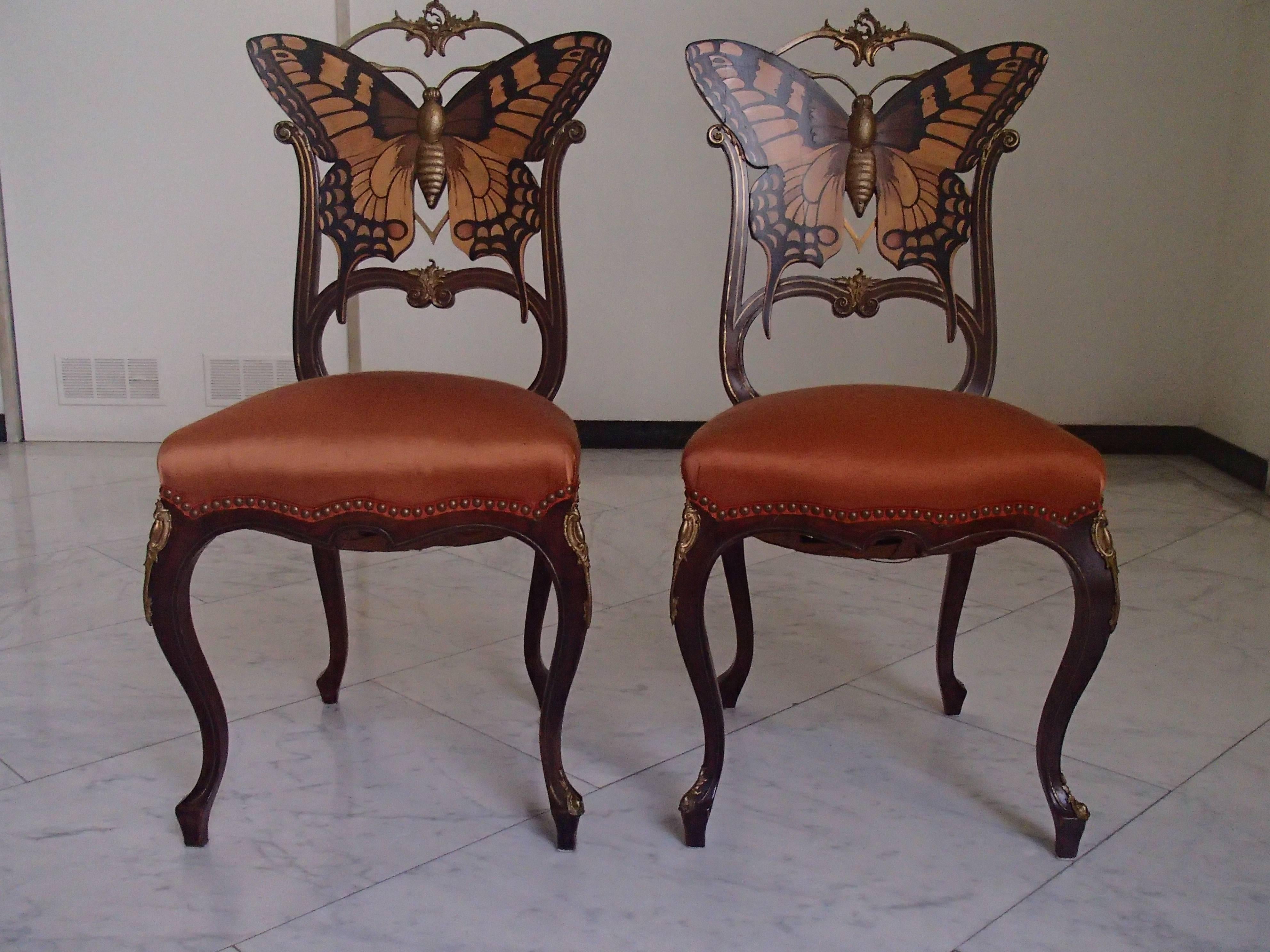 Early Art Nouveau pair of butterfly inlaid chairs with brass ornaments.