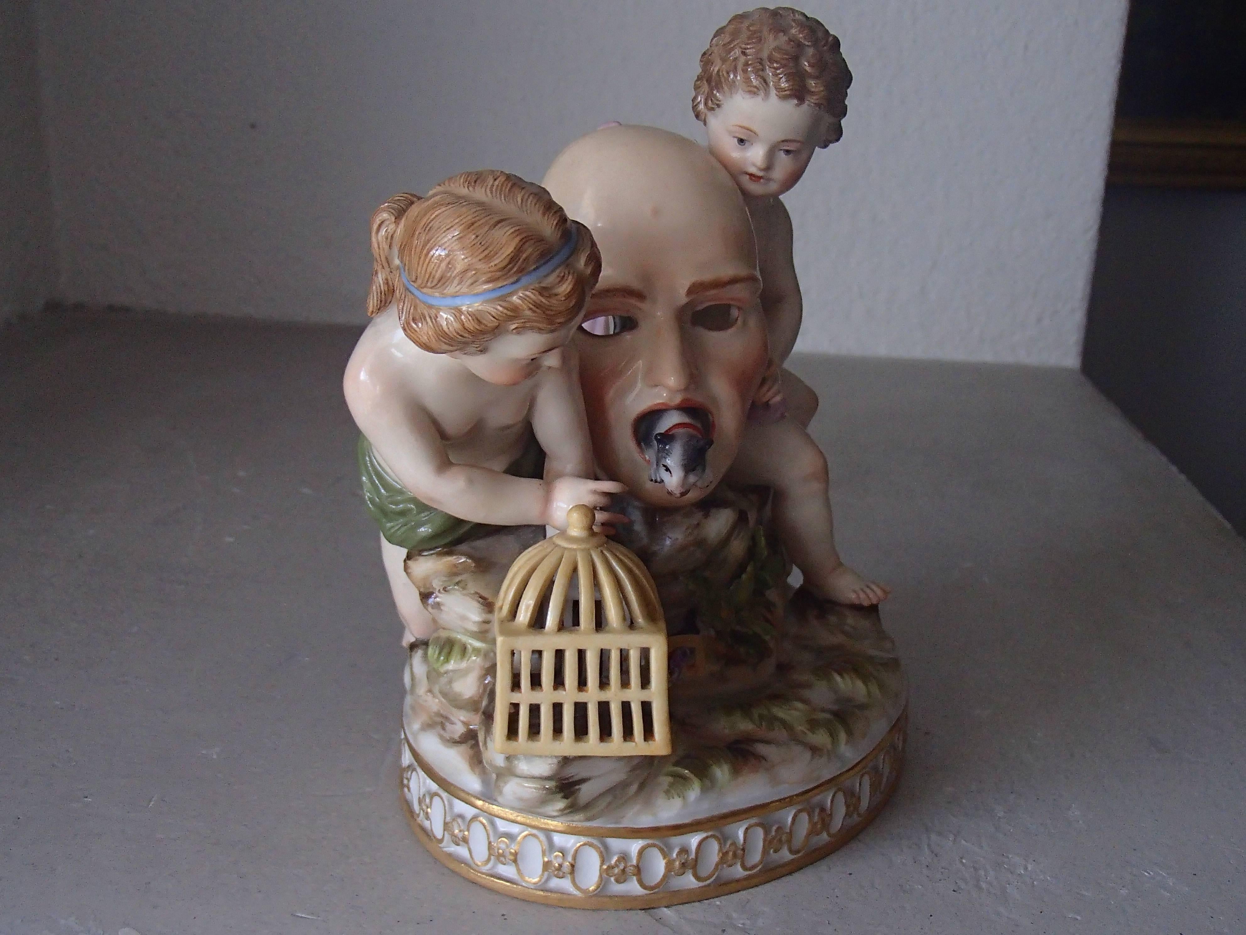 19th century Meissen figurines attributed to Ernst August Leuteritz with two putts holding a masc from which mouths come a little dog and a birdcage. 
Perfect condition.