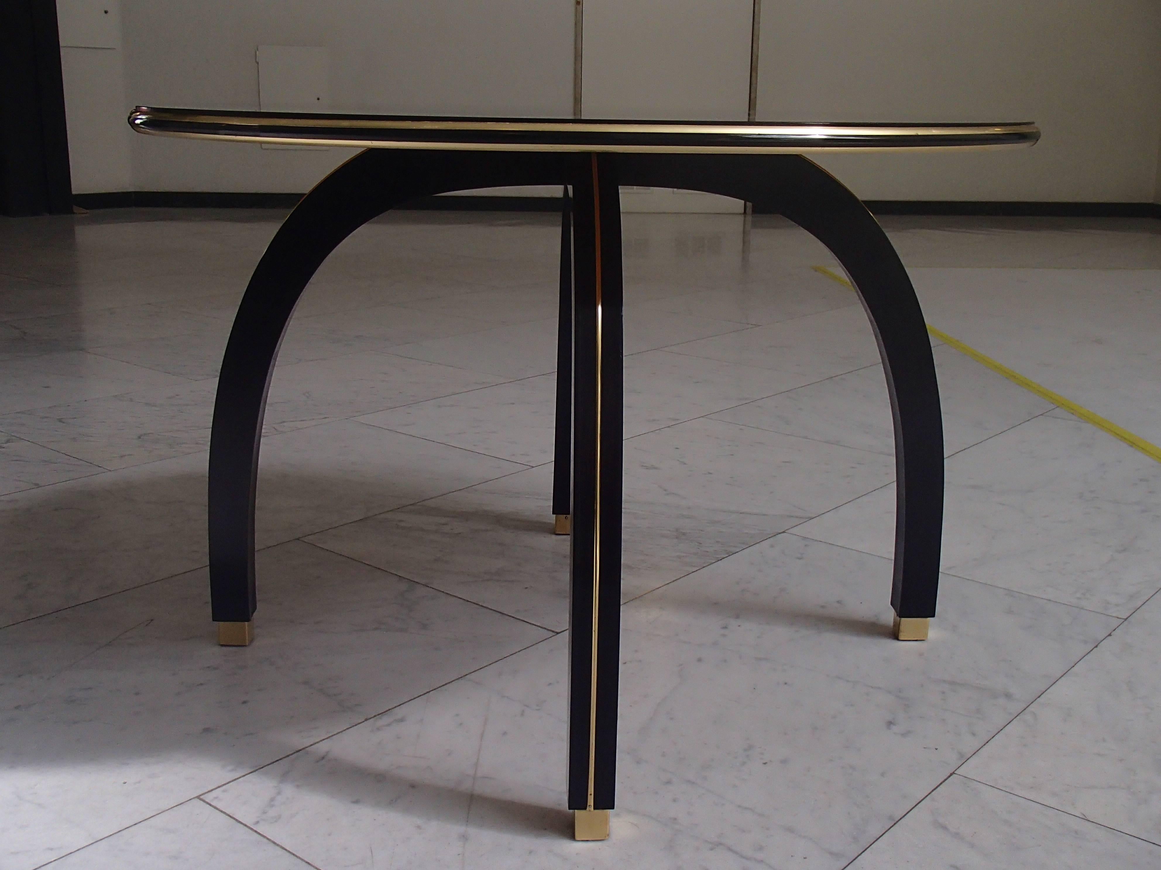 Very elegant round side table with black glass top with brass ornaments and legs.