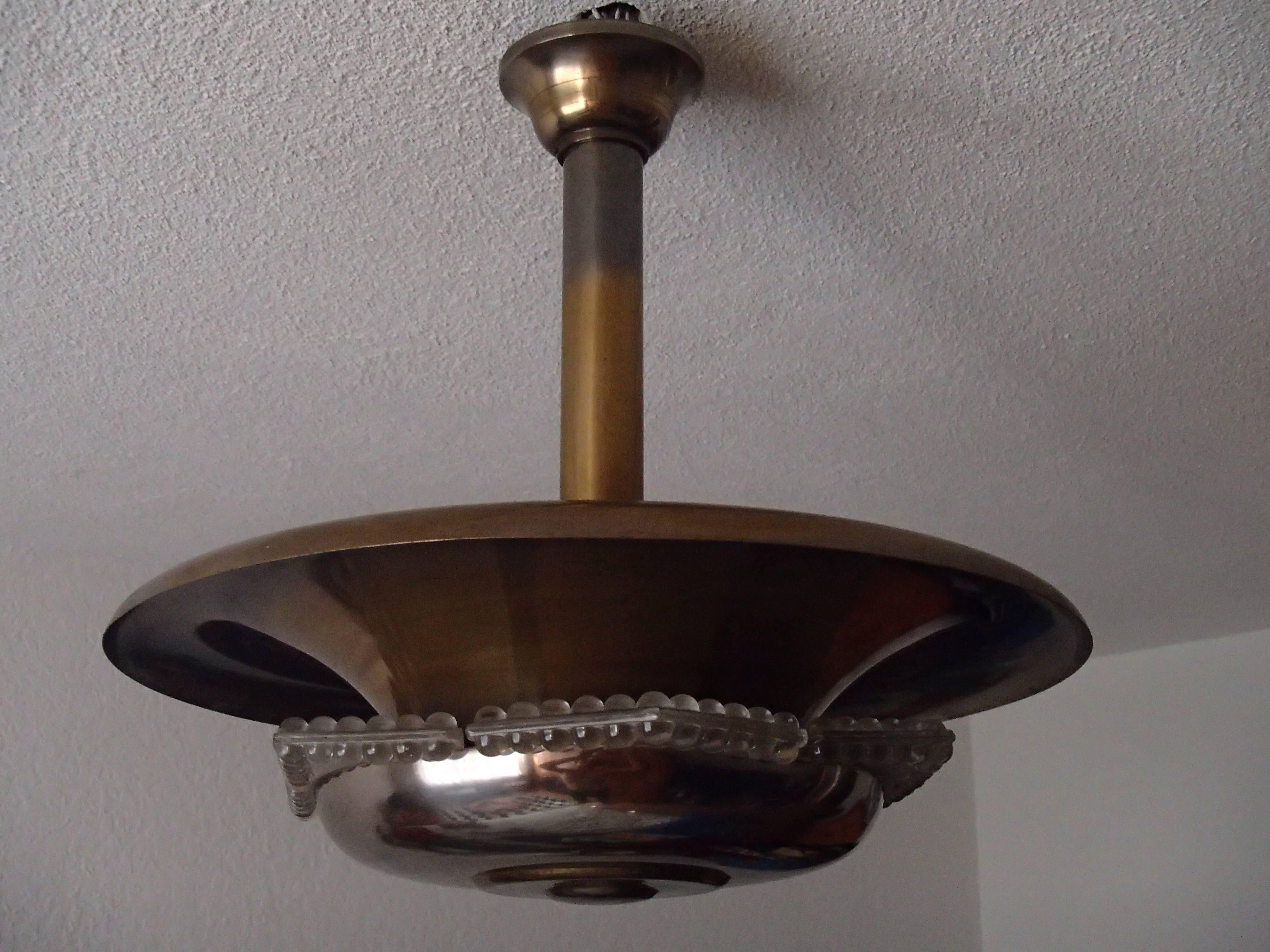 Art Deco chandelier brass  tinted metal with glass inlays gives a beautiful light shining trough the glass 