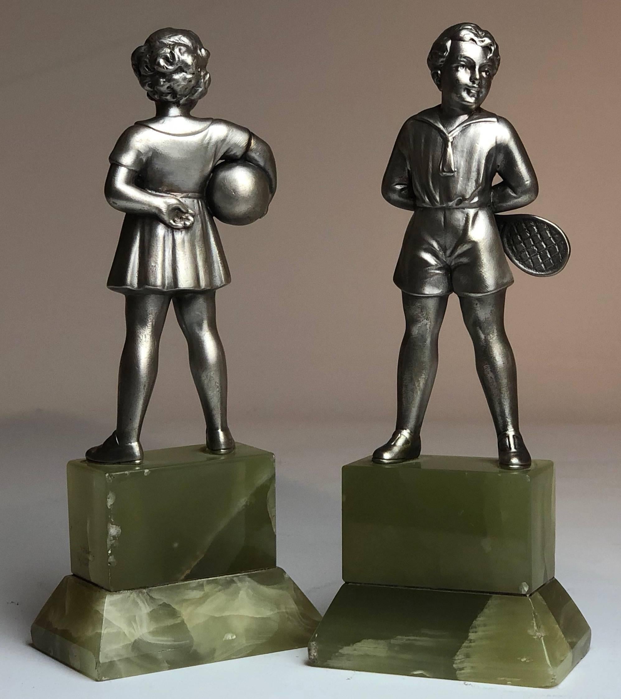A delightful pair of early 20th Century Austrian cold painted bronze figure of a young boy tennis player holding his racket and young girl holding a ball, both signed R.Lor and raised on a shaped Brazilian green onyx plinth

Each stand 7" tall