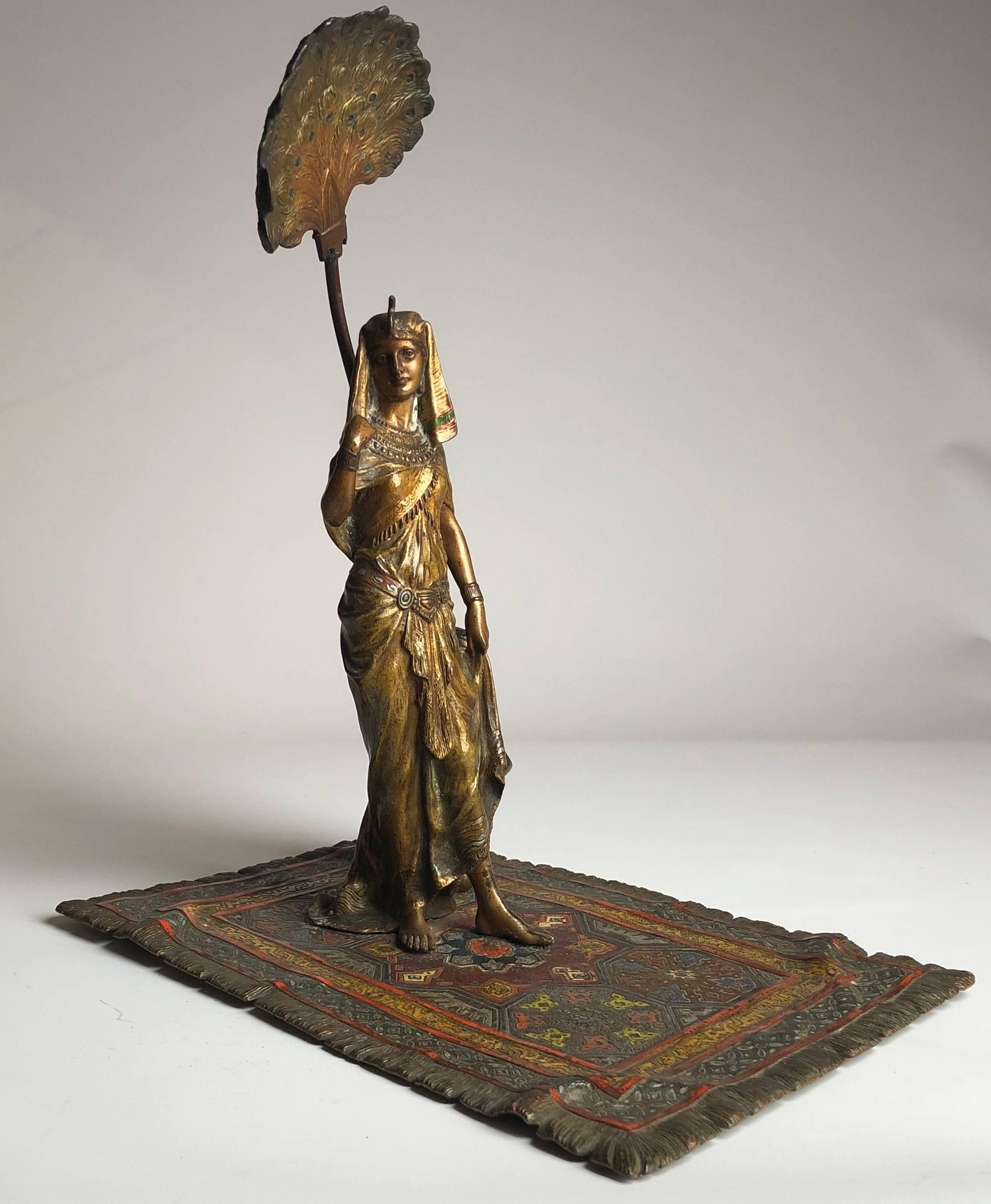 A superb early 20th century cold painted Austrian bronze study of Egyptian queen on carpet with servant boy holding peacock feather sun shade, circa 1900

Stamped with the Bergman foundry mark and signed Nam Greb.

The piece measures 10