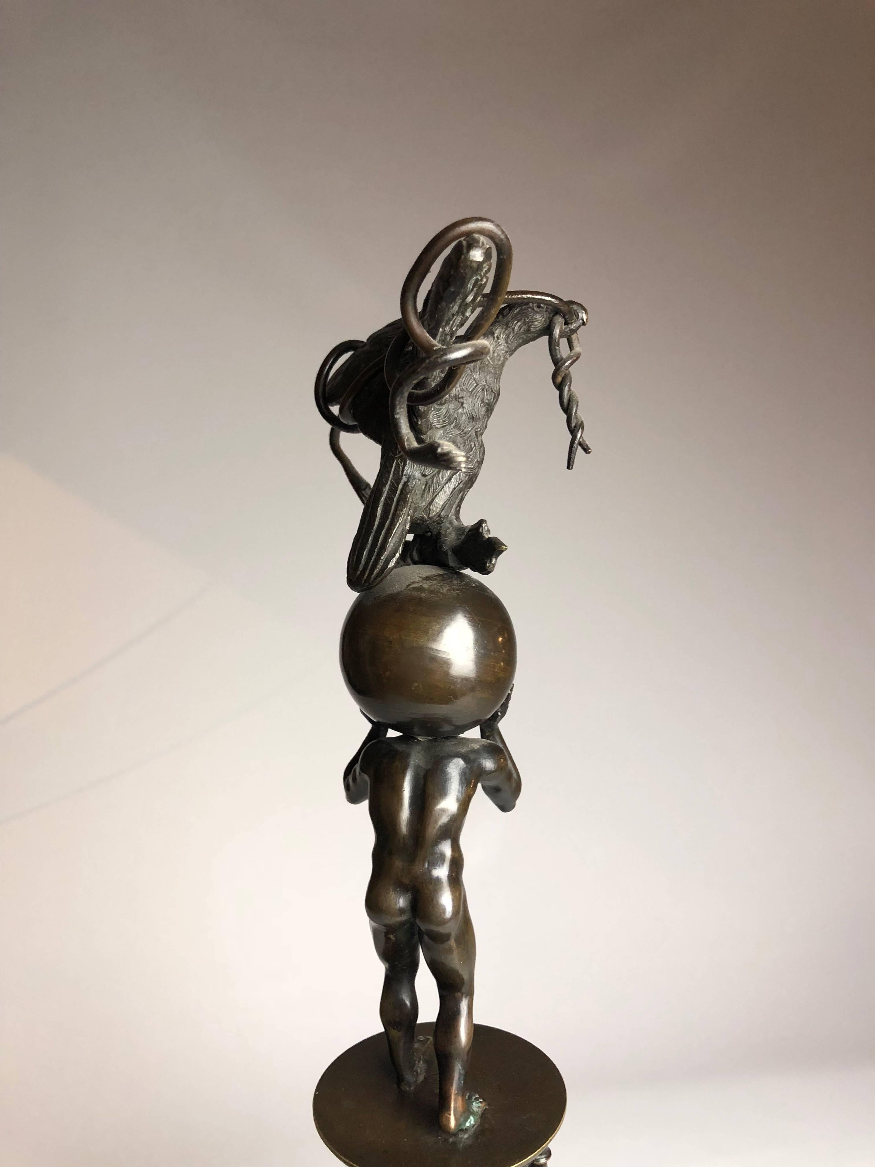 A very interesting Grand Tour Bronze Group, dating from around 1860 in neoclassical style tripod standard with successive stages of a tortoise between winged lion herms, a piping faun within a balustrade, and a nude Atlas figure supporting a globe,