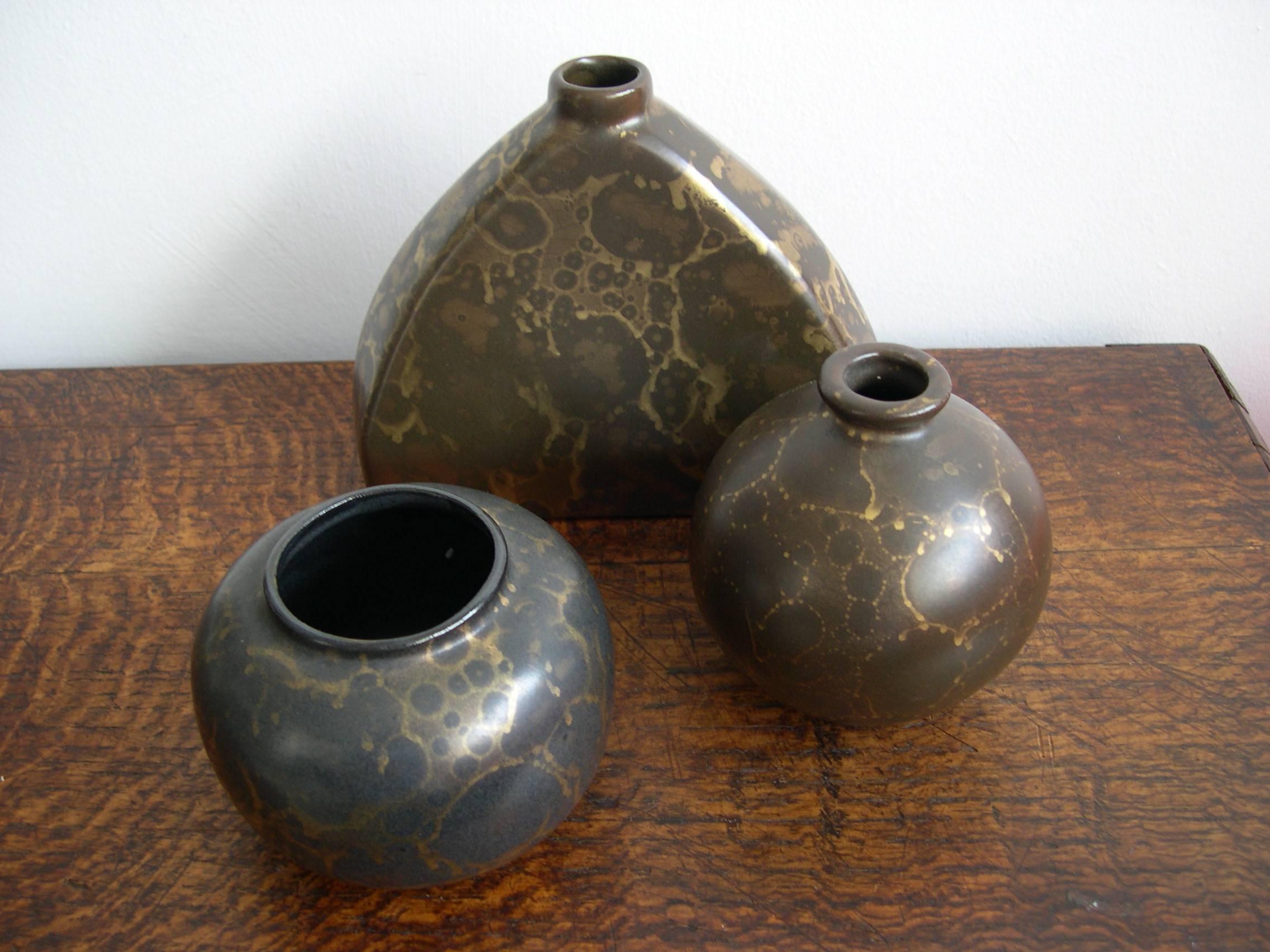 Attractive set of three sculptural vessels by French ceramicist Lucien Brisdoux with gold metallic glazes in various tones. Based out of the Loire, Brisdoux produced these wares for a short period in the 1930s as the manufacturing technique proved