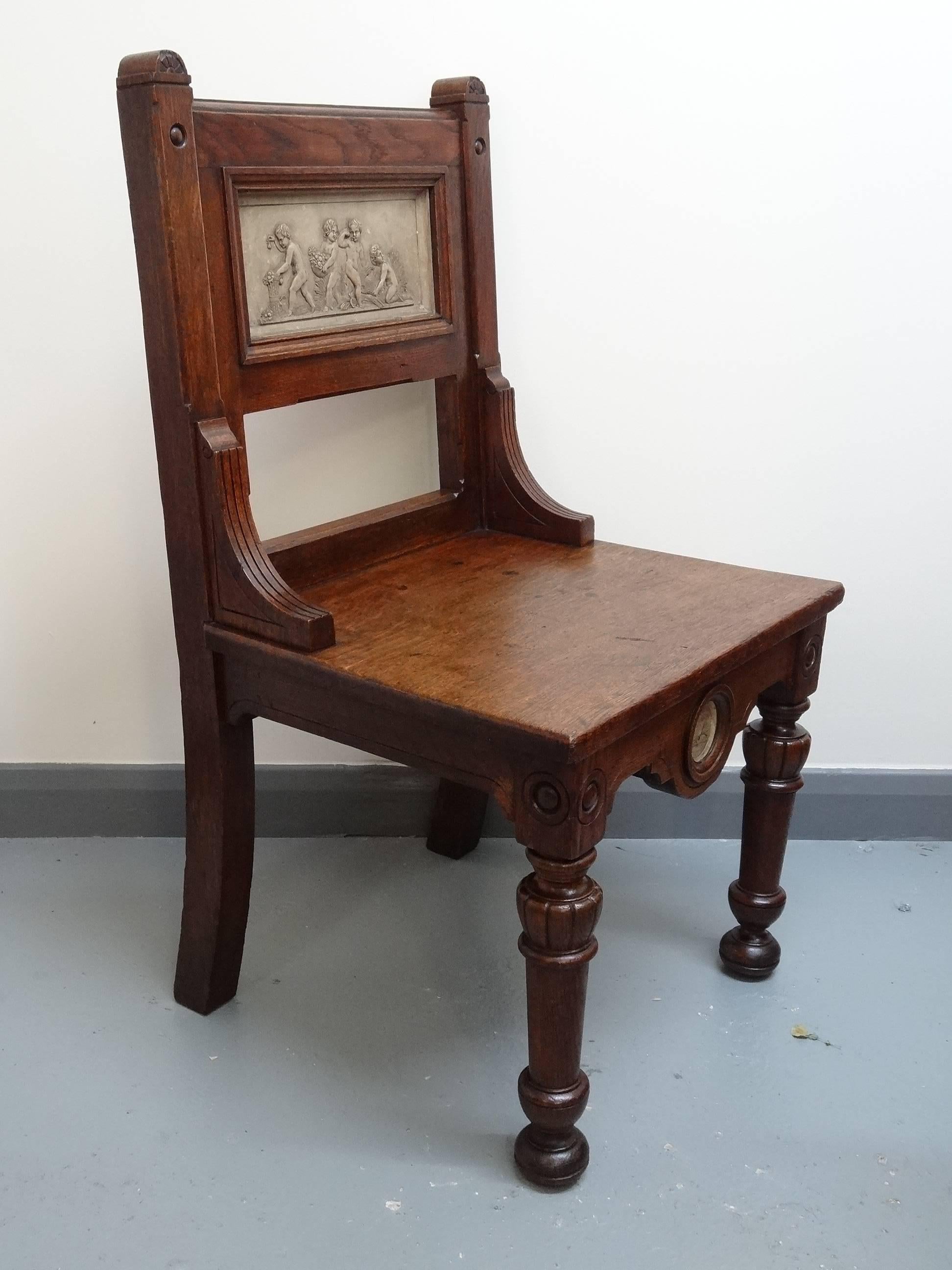 British Arts and Crafts Gillows oak hall chair with putti plaster panels circa 1880s For Sale