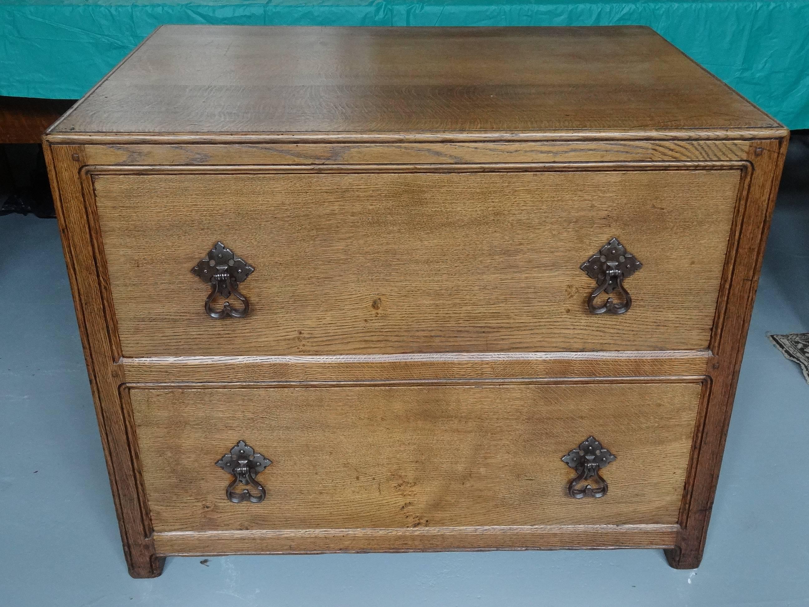 A fine quality large and deep oak chest of two very deep drawers, with good solid gothicky chunky iron drop handles; by Liberty & Co, circa 1924. This is from a range of furniture specially made by Edwin T Hall & Edwin S Hall for Liberty