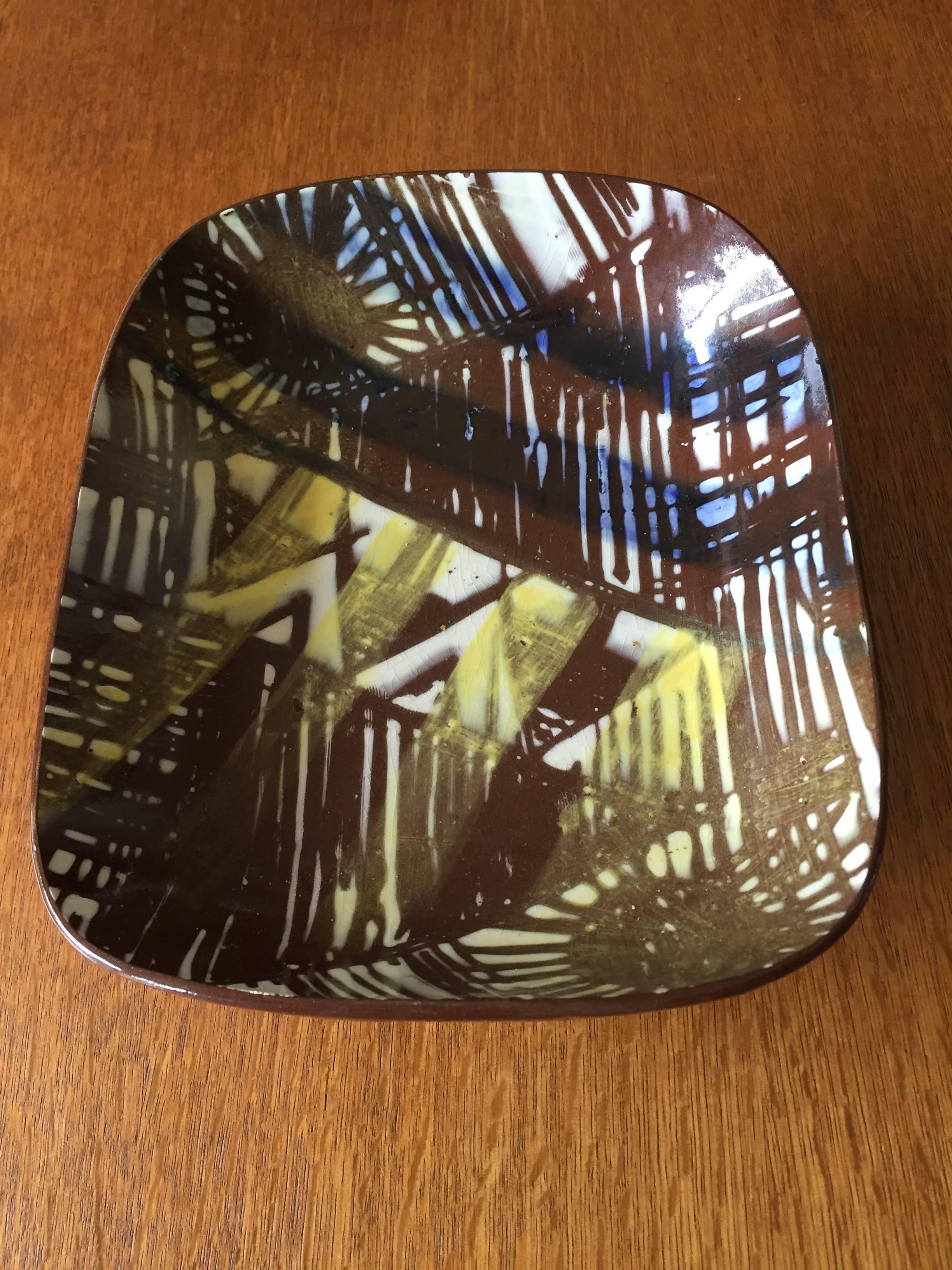Graphic Mid-Century Modern shallow rectangular dish set on four triangular feet of glazed terracotta. The decoration is white and yellow glazes in the manner of James Tower or Lucienne Day. Signed and dated to base 1956 FSH for Frederick Harrop, a