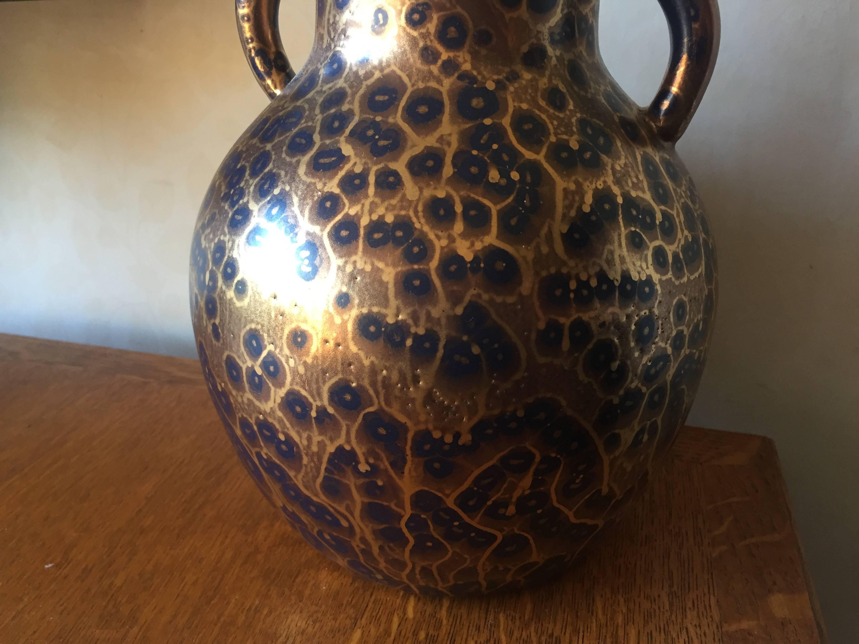 Striking deep blue glazed shouldered vase with handles covered in a unique gold glaze. The signature to the base for Leon Pointu 1879-1942 who worked with this technique in the 1930s. This is a large piece and very imposing. Based in St Amand en