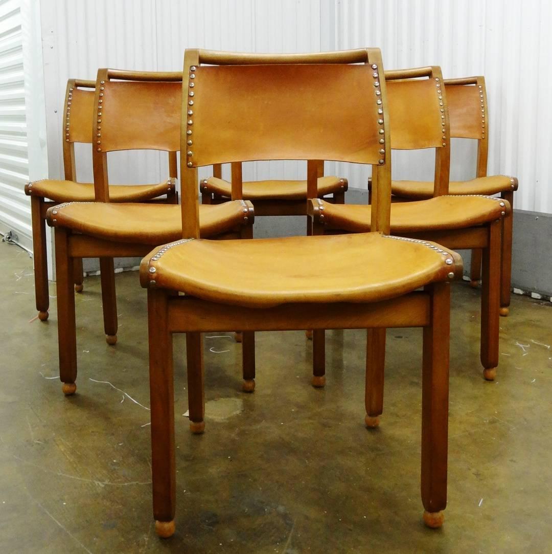 A superb and stylish set of six fruitwood (possibly beech) framed dining chairs with original studded leather seating and backs, from the workshops of the internationally renowned master craftsman/designer furniture maker, John Makepeace, OBE FCSD