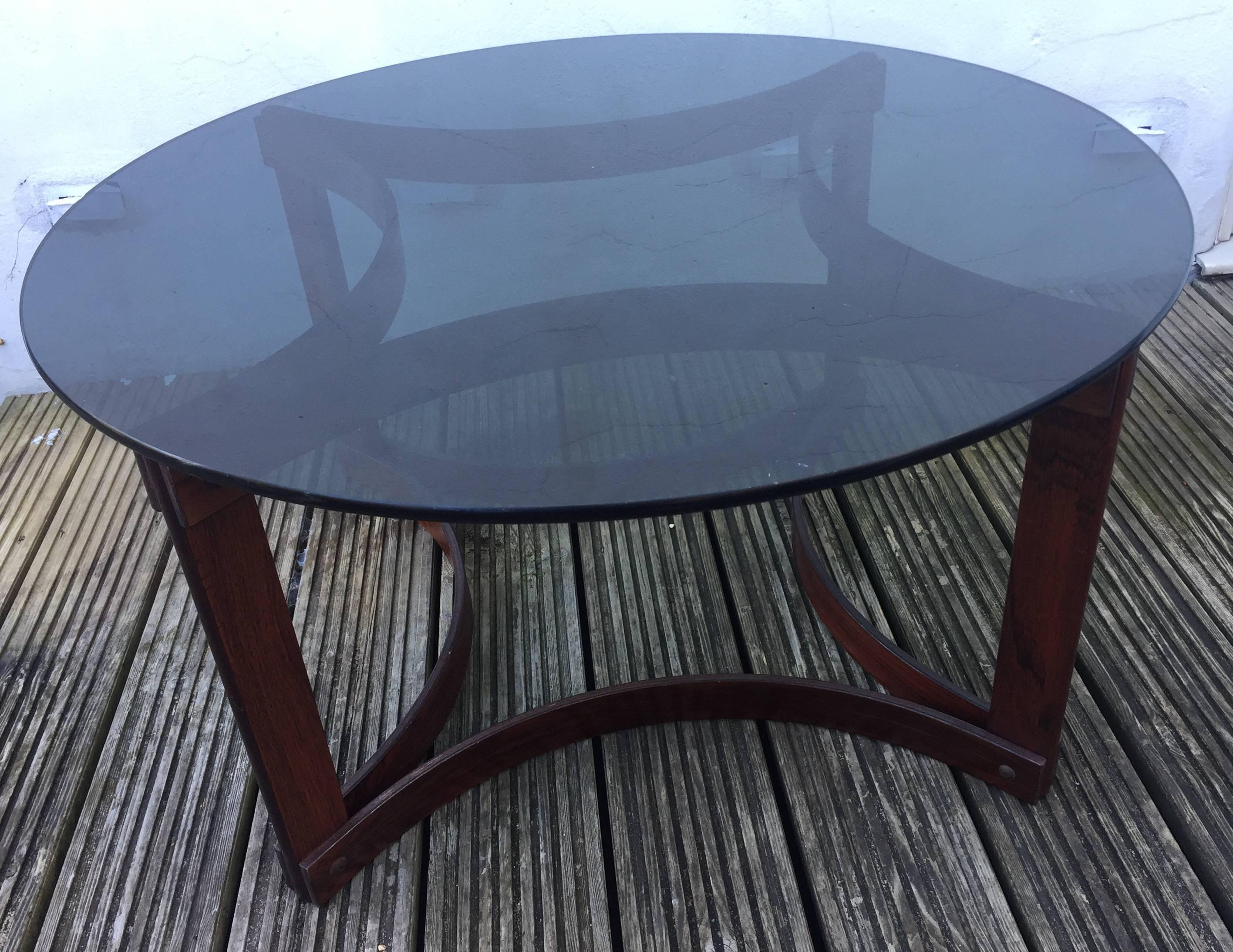 Attractive and well designed Ingmar Relling for Westnofa Midcentury rosewood and rosewood veneered laminate coffee table with original heavy smoked glass circular top and good figuring. The bentwood connecting strips are held in place by screws in a