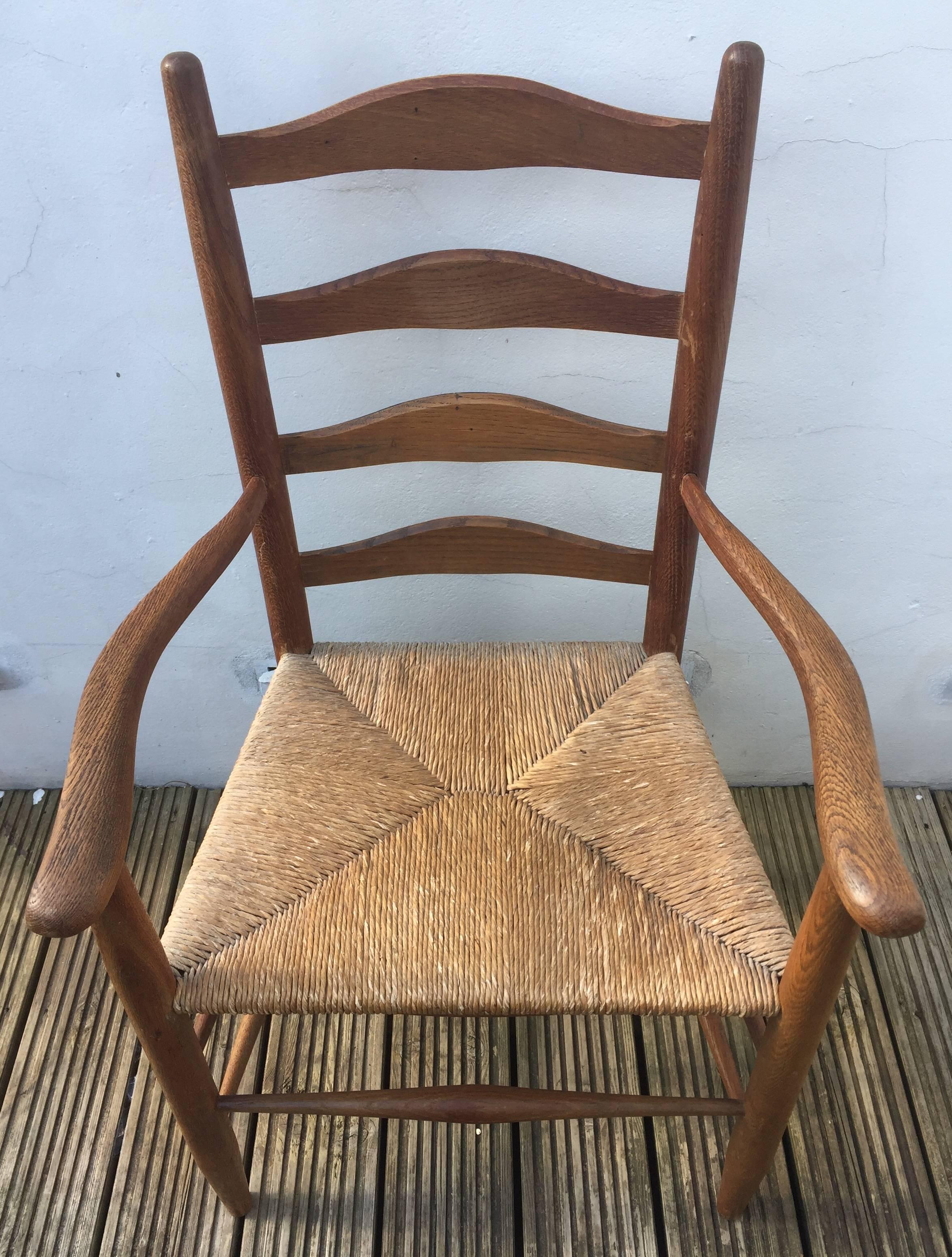 Beautifully handmade ladder back armchair of generous proportions by Ernest Gimson with rushed seat and tenon joints as well as handmade iron nails. Crisp chamfering to the graduated back rails.
