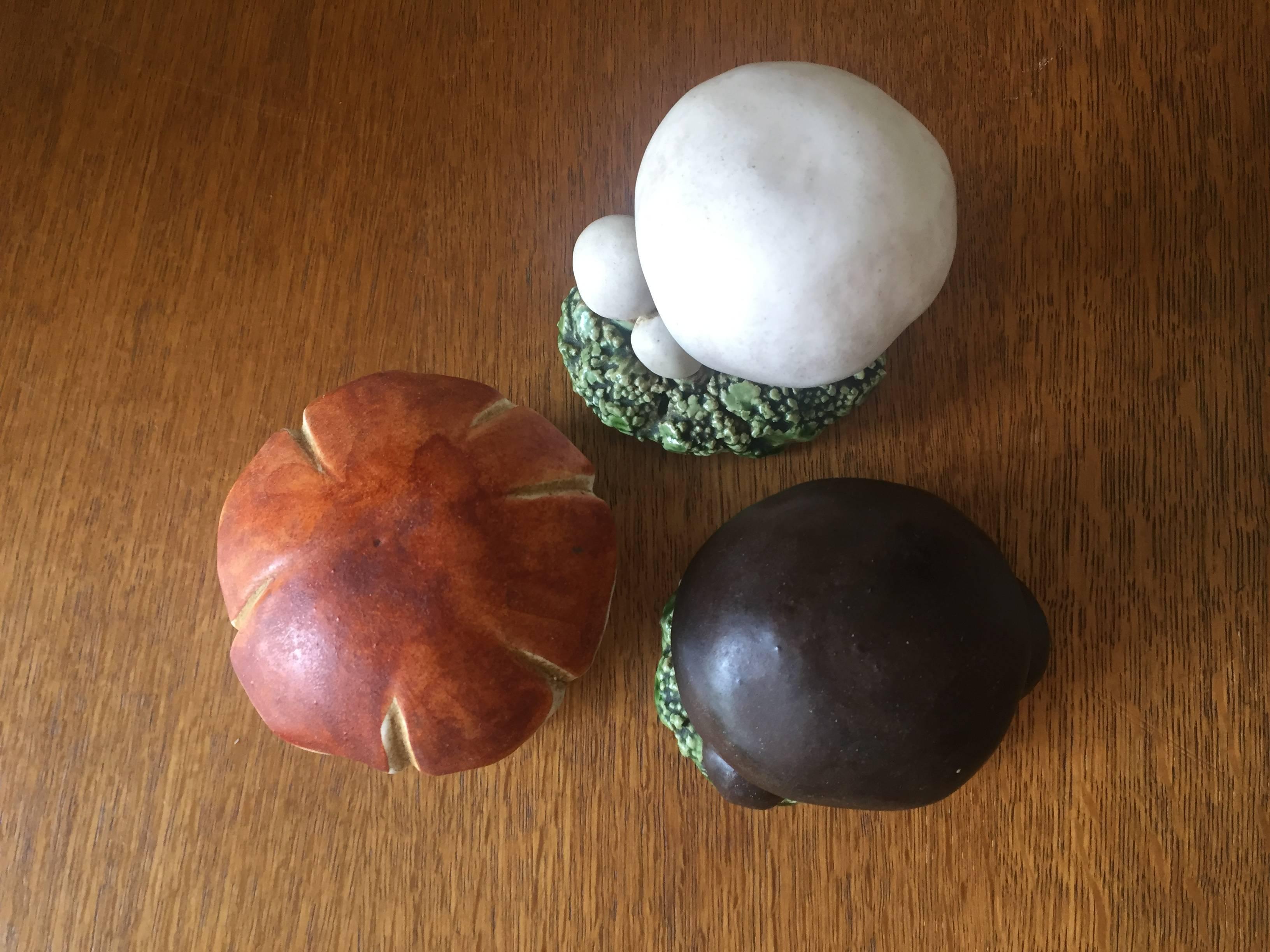 Three decorative and very naturalistically executed ceramic mushroom specimens set on clay "grass". These have been hand-painted with great care and were made by Marcel Guillot at his workshop in Paris. Each has the French common name