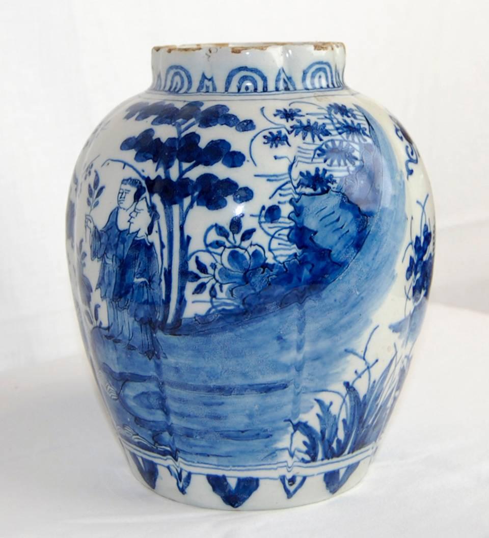 Of Baluster form, beautiful blue and white hand-painted delft vase decorated with various birds and what would be described as cherry trees in blossom. The scenery depicts five characters in Chinese garments. Separated by water, on the left, a