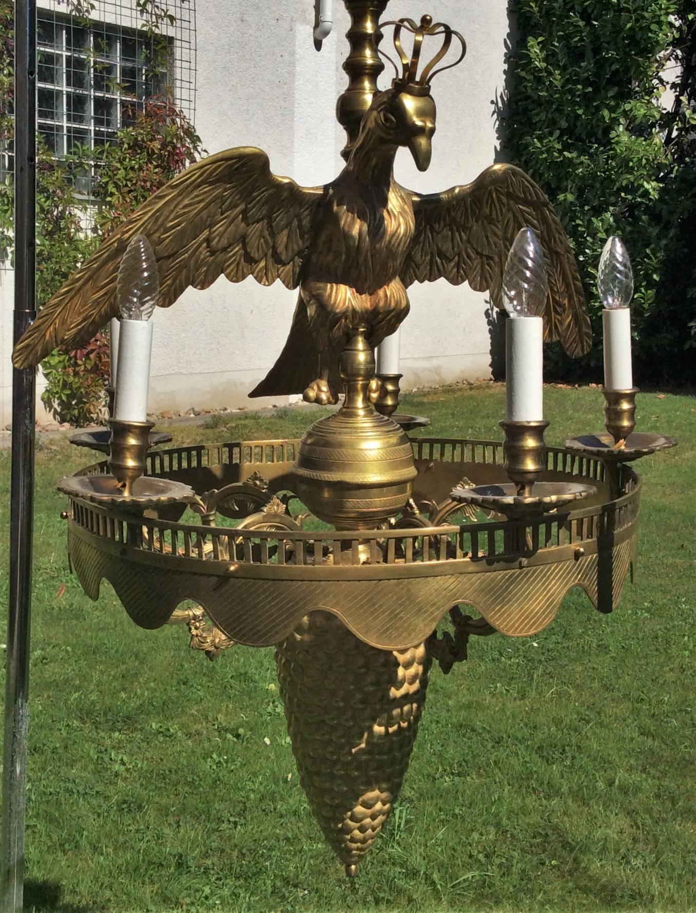 Rare one-of-a-kind massive molded five-flamed chandlier, probably German or Dutch, circa 1830, Empire style. 
A massive bronze crowned eagle with open wings above a wavy ribbed ring with five flames and a large Columbine/Aquilegia cup/chalice.