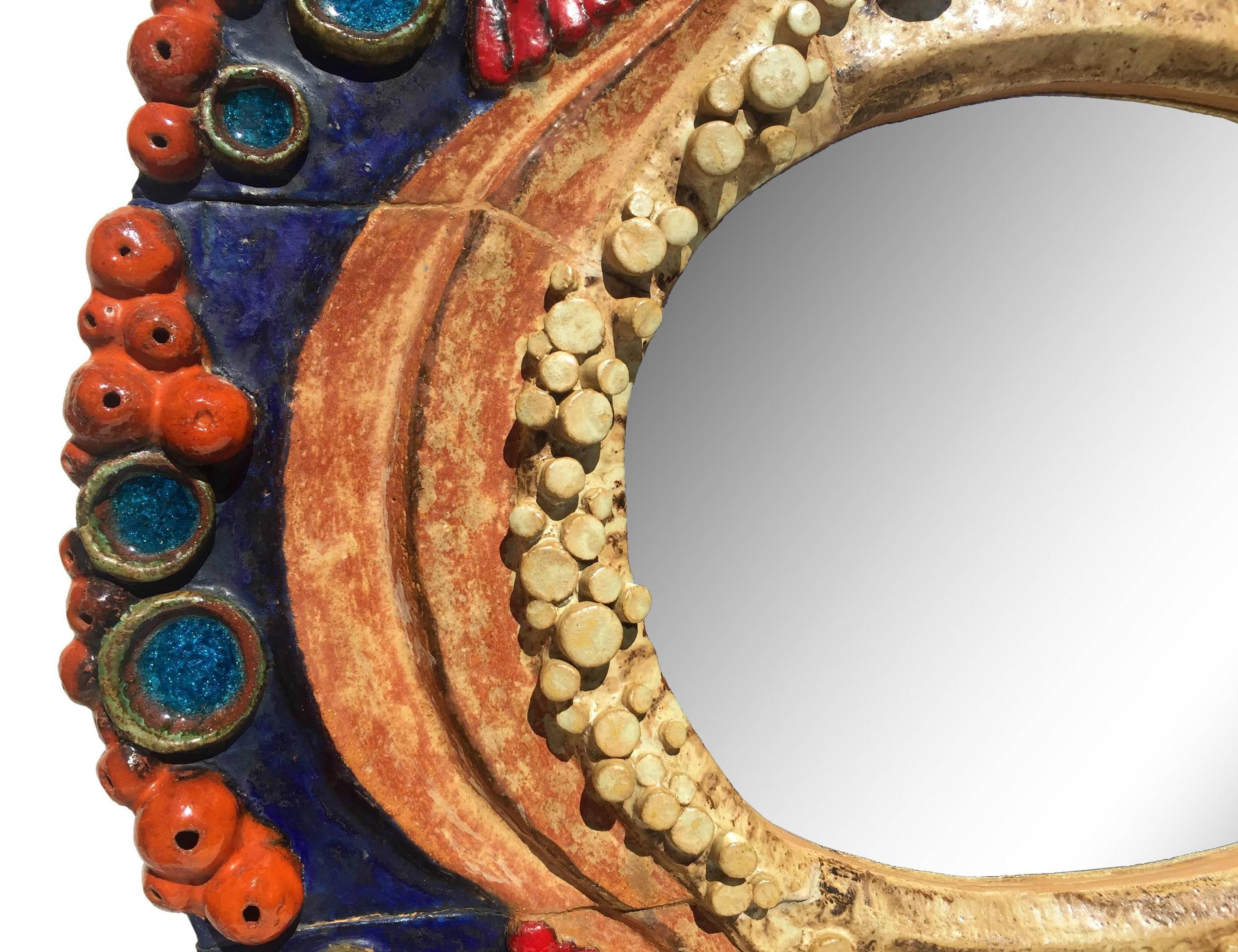 Exceptional and unique sculpted one-of-a-kind art pottery mirror by Assenmacher, circa 1970. The embellished frame has a relief of mysterious gem-like cascades. The colorful rainbow presentation reminiscences to medieval Gothic cathedrals, to