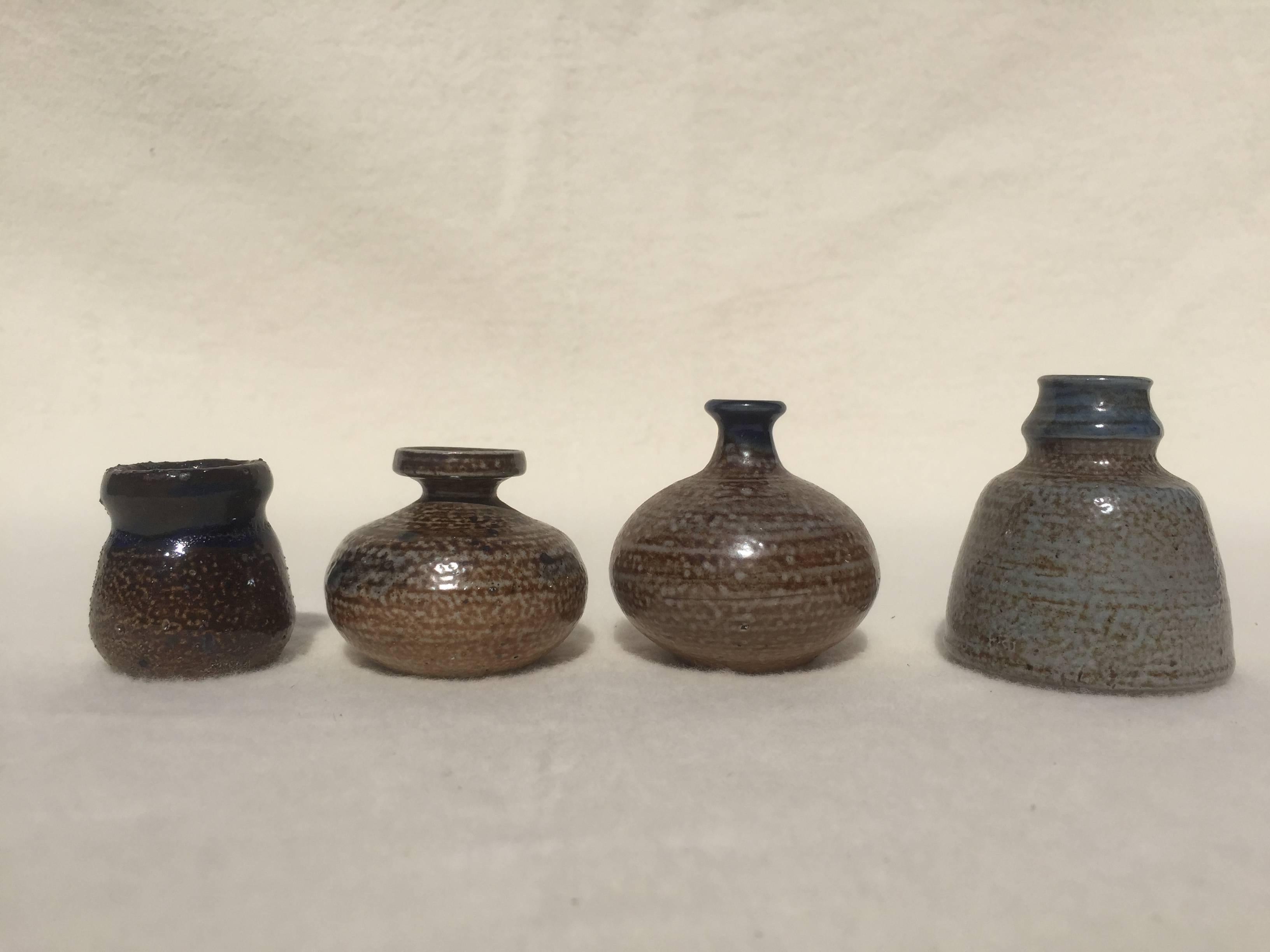 Set of four unique Miniature Art Pottery miniature vases by Lilo Grinzoff-Assenmacher, Germany, 1960s. The vases have classical shapes and are salt glazed in cream, blue, green and brown. Salt glazed ceramics is burned at very high temperatures and