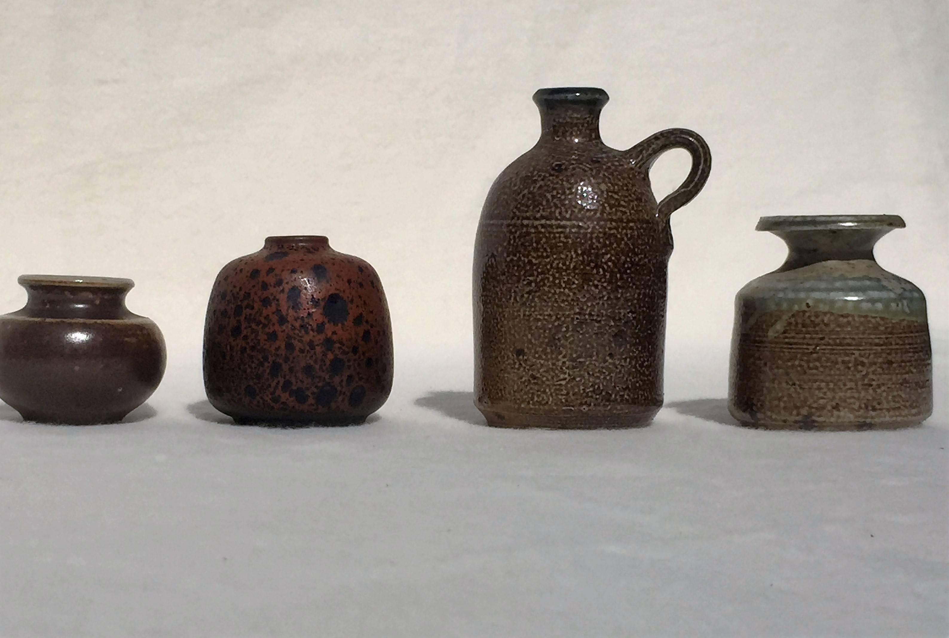 A set of four unique miniature ceramical vases, one of them marked underneath 188, the other three ones by Lilo Grinzoff-Assenmacher, Germany, all Mid-Century, circa 1960. The marked one has a spotted black and red glaze, the other three ones are