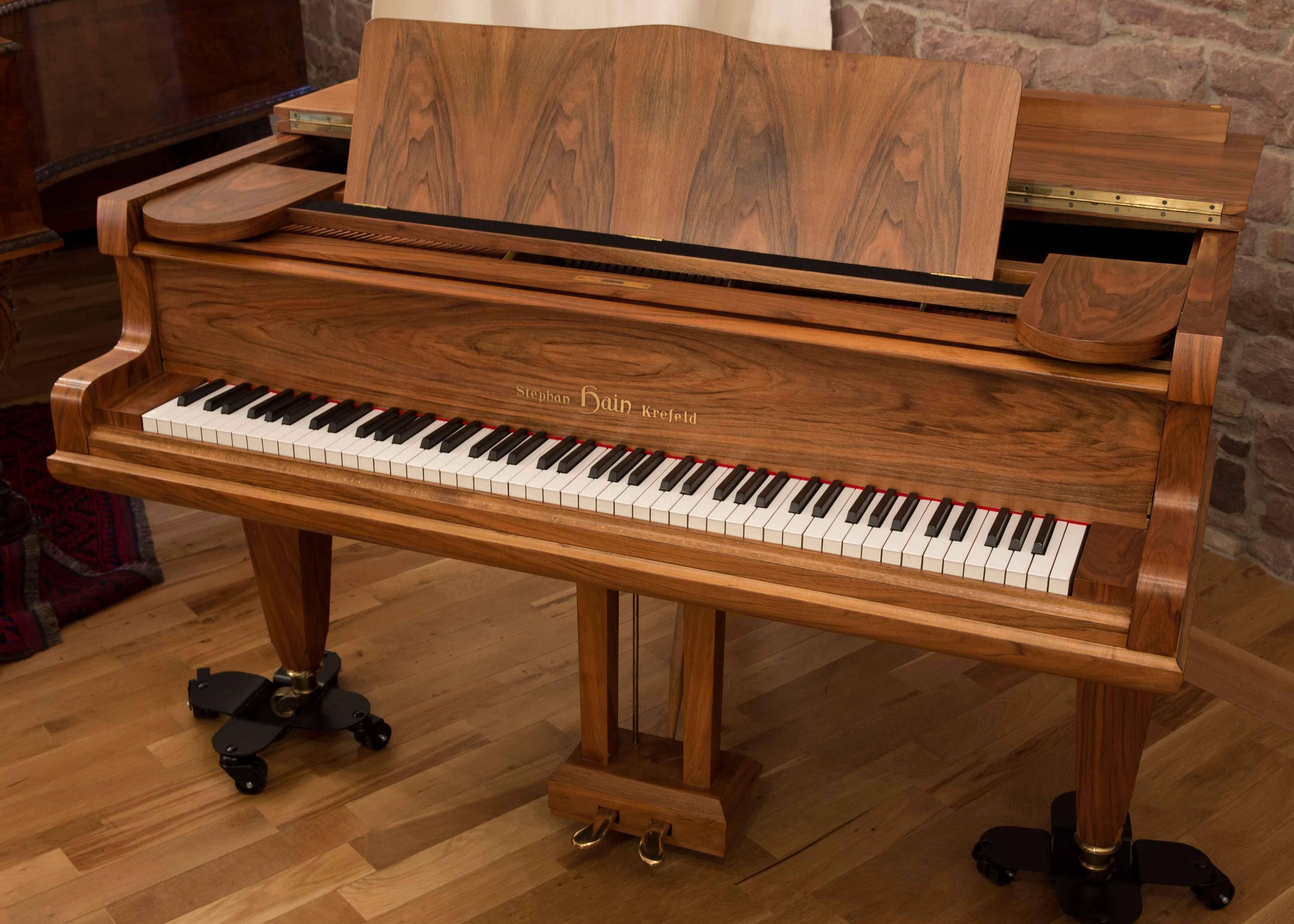 German baby Grand Piano by Stephan Hain, Krefeld, manufactured 1964. 88 keys, synthetic white key covers, ebony black keys. It has straight tapered legs and a walnut case in a perfect satin finish. Fully original and rare to find, a Mid-Century