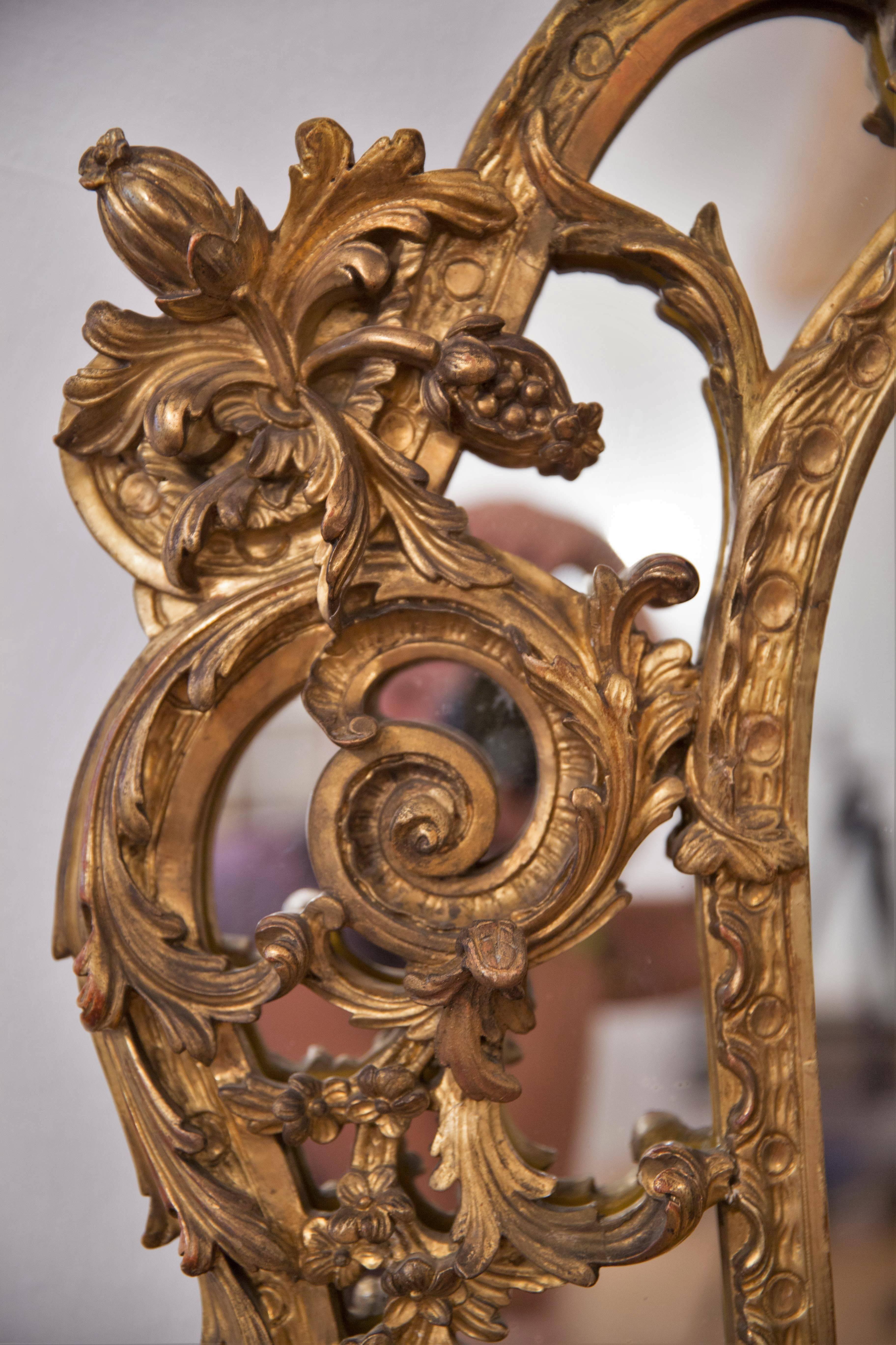 Large French Louis XV style mirror from the Rococo revival period mid of 19th century, circa 1860, provenance from a French Chateau.
Pierced gilded wood and gesso. Very fine work, elegant serpentine shape, richly carved asymmetrical delicate