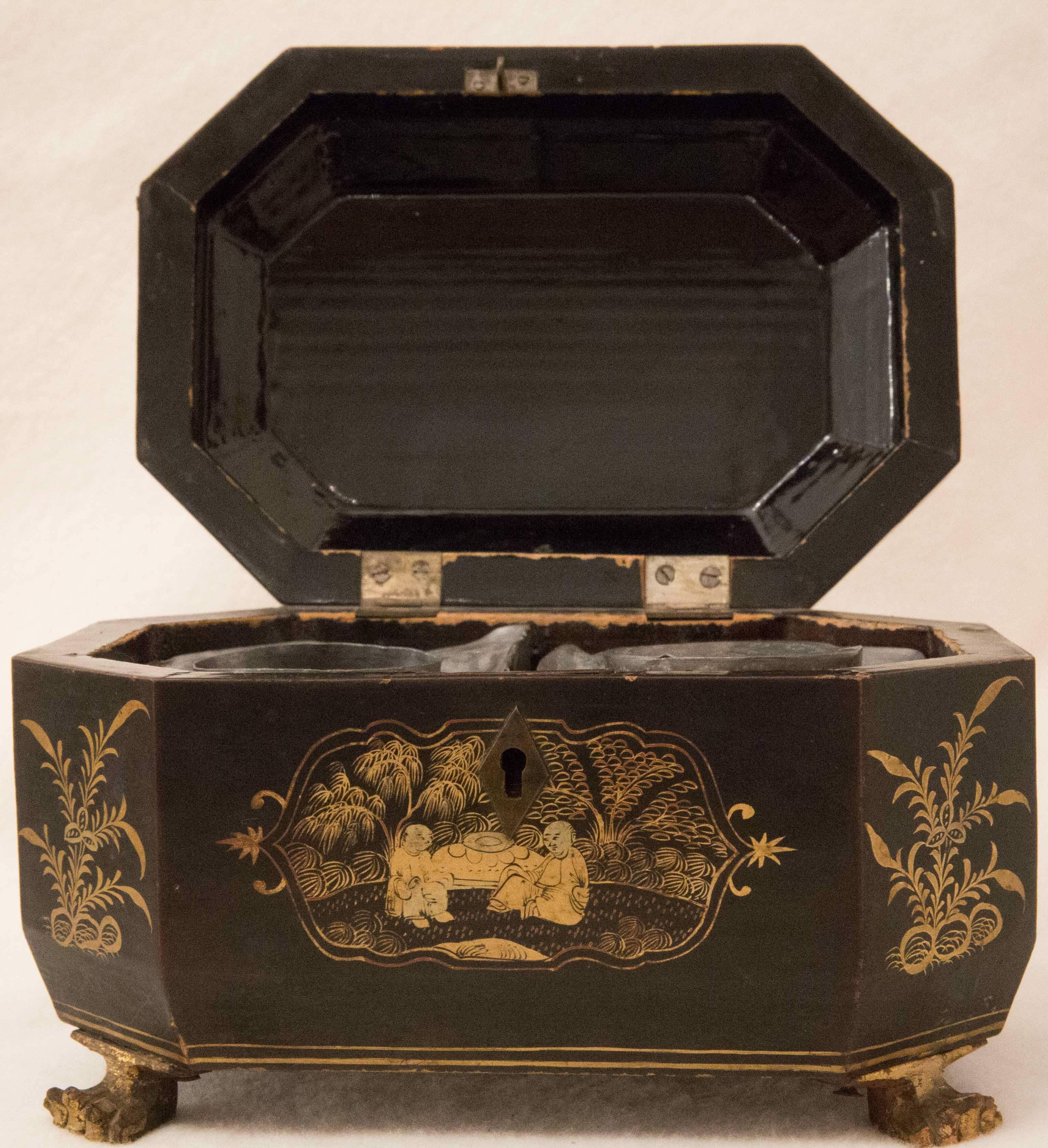 Beautiful 18th century Chinese export lacquered tea caddy in an octagonal shape with gilt chinoiserie decoration and cast gilded paw feet. Interior is fitted with a pair of pewter tea canisters. One set of inner lids is missing. Certain normal wear