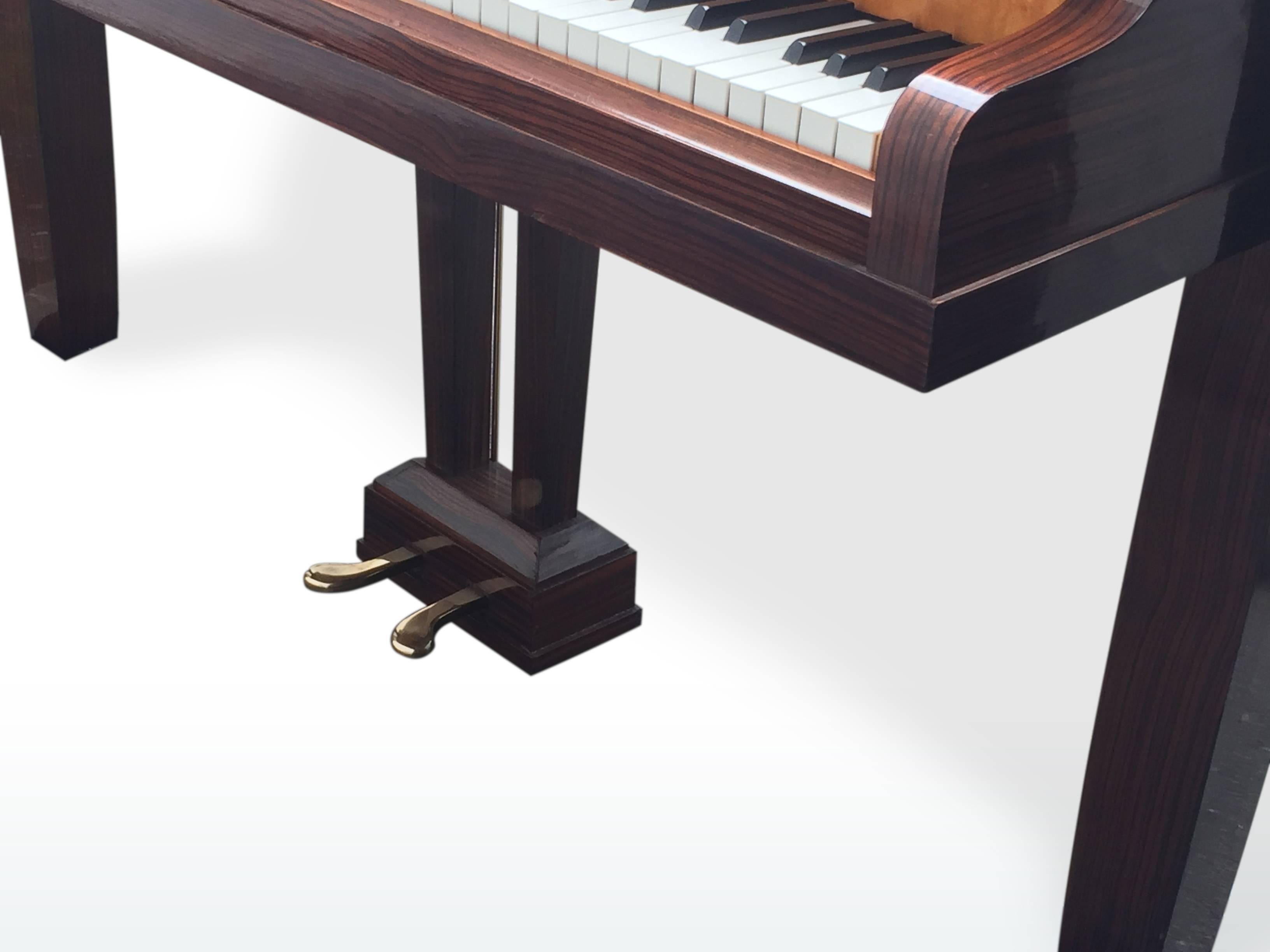 A real period Art Deco/ Mid-Century-Modern/ Modernist baby grand piano by Pleyel, Paris, manufactured approximately in the year 1956. The bi-colored veneer is made of Macassar ebony and beautiful French citrus wood. The lemon wood looks a bit like