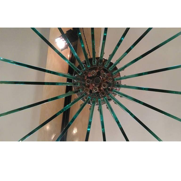 Important round chandelier, by G. Reggiori. The round structure is a fine chrome plated brass; there are 24 crystal plates, shaped and crinkled like petals. The glass is the typical Fontana Arte glass, a bit light blue. It is dated 1968. The