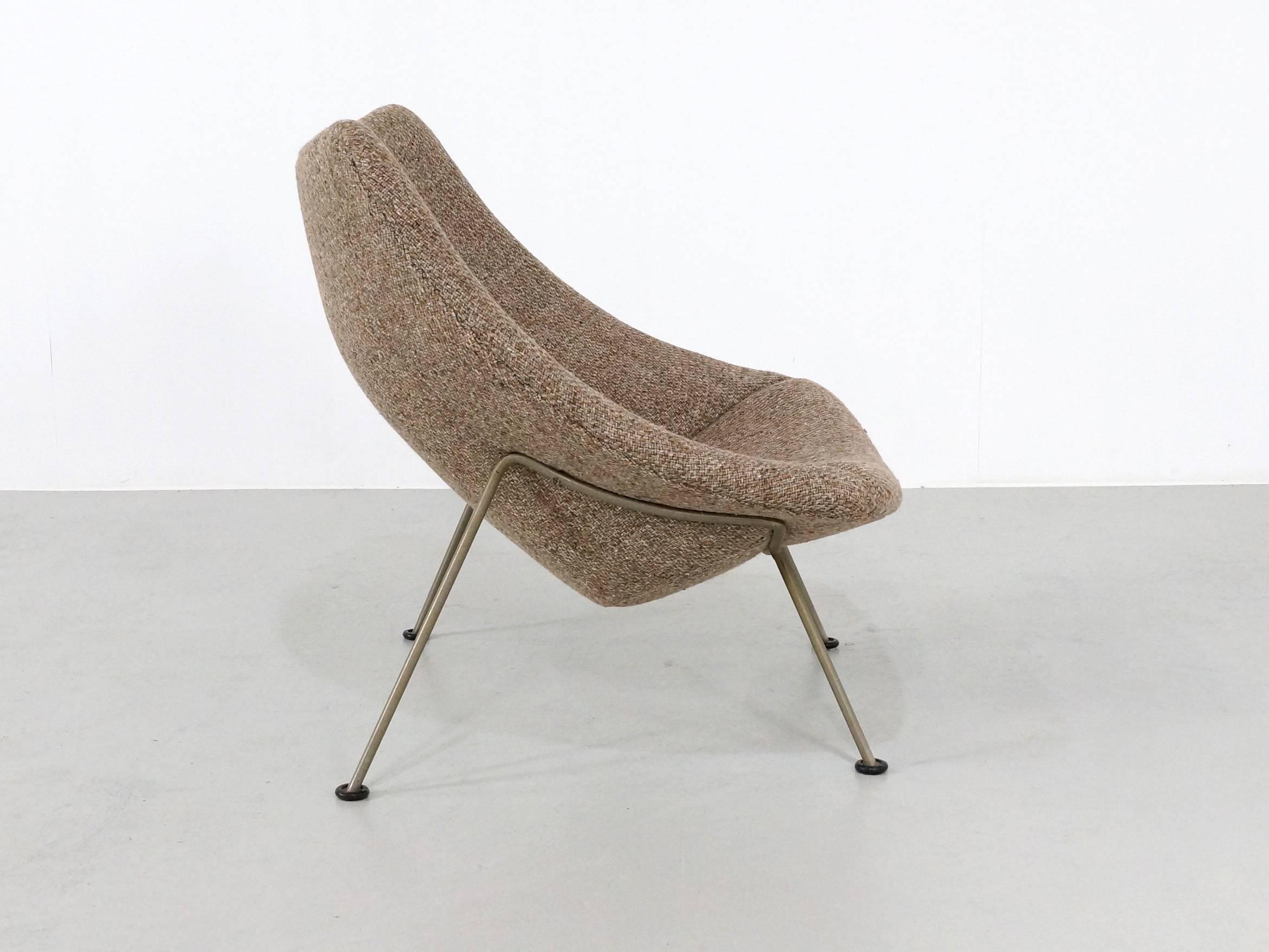 This Oyster chair designed by Pierre Paulin in the start of the 1960s has a nickel metal base and its design is so Minimalist that the wool upholstered wooden seating shell seems to float.
The wool upholstery with the typical 1960 brown grey color