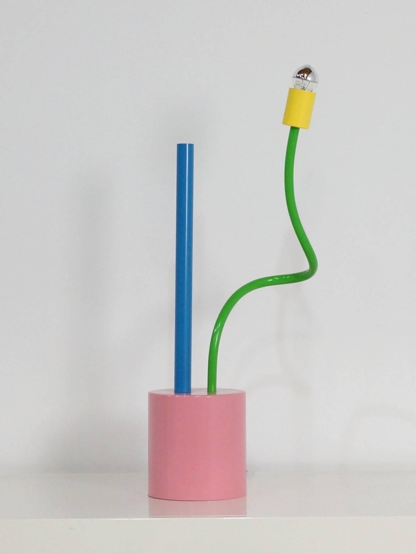 One of the early interior pieces from Michelle de Lucchi for Memphis, designed in 1978 this lamp was for the end of the 1970s period very modern in bright pink, green and blue colors and the "flower-power" design. The lamp is in very good