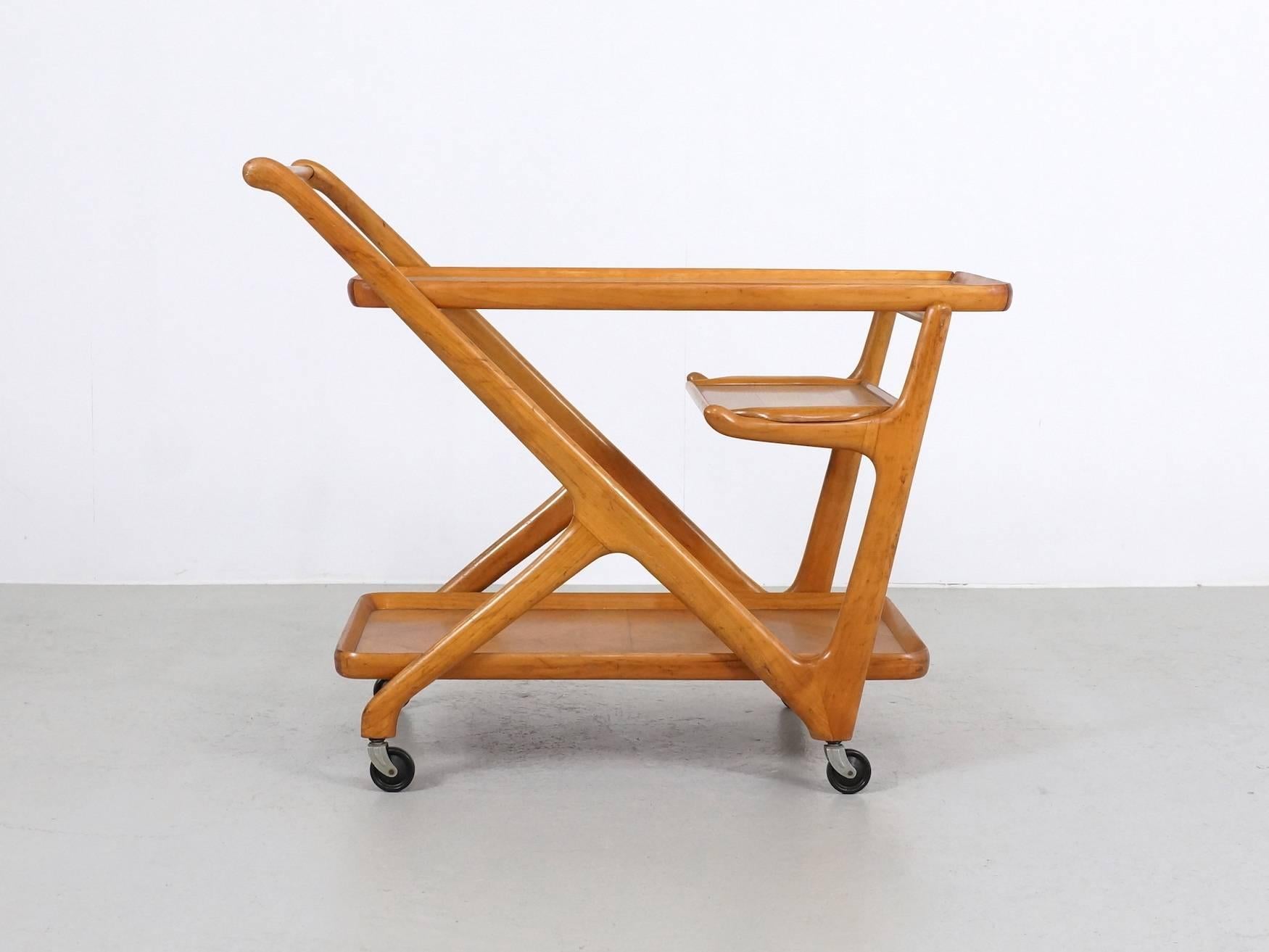 Solid walnut wood bar cart designed by Cesare Lacca for Cassina in 1951. These trolleys are well-known and the separated serving tray under the top make it an attractive decoration piece. The beautiful organic shape makes it a beauty!!
The glass