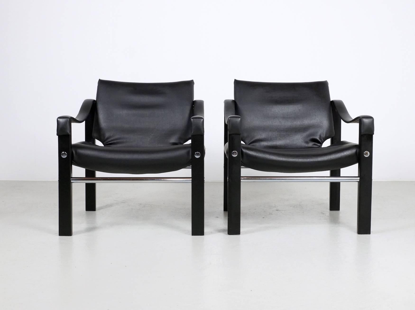 Set of two black leatherette Chelsea chairs designed by Maurice Burke for Arkana ( GB ) These chair also called safari chairs are made in solid black painted wood with chrome tubular pieces in the middle. The chair are in good condition and very