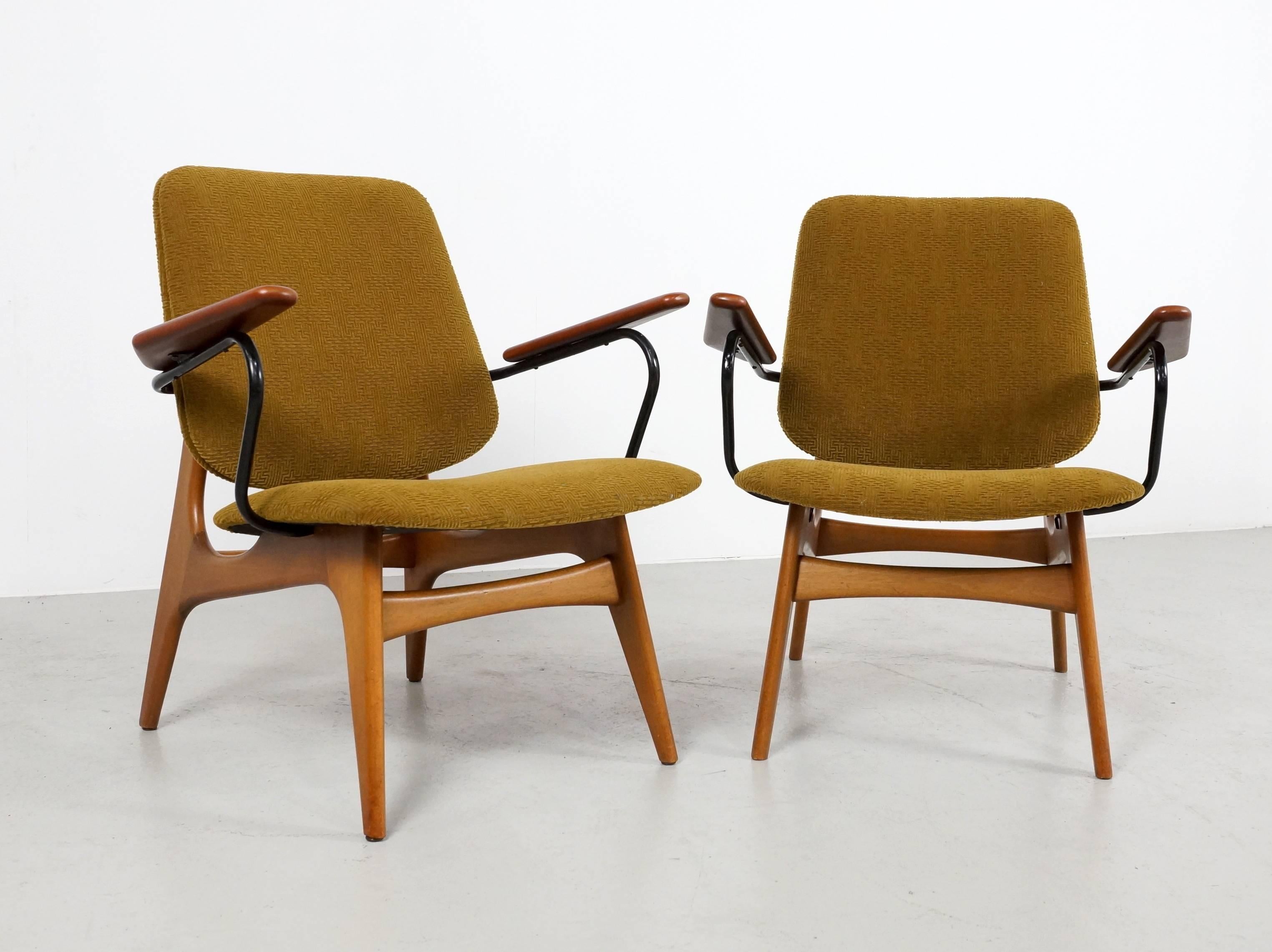 Pair of 1960s Dutch modernist easy chairs on a teak wooden base. The organic shaped teak armrest are supported by a black metal tube under-need. 
The chairs are newly upholstered in a highly exclusive textured fabric original from the 1960s.