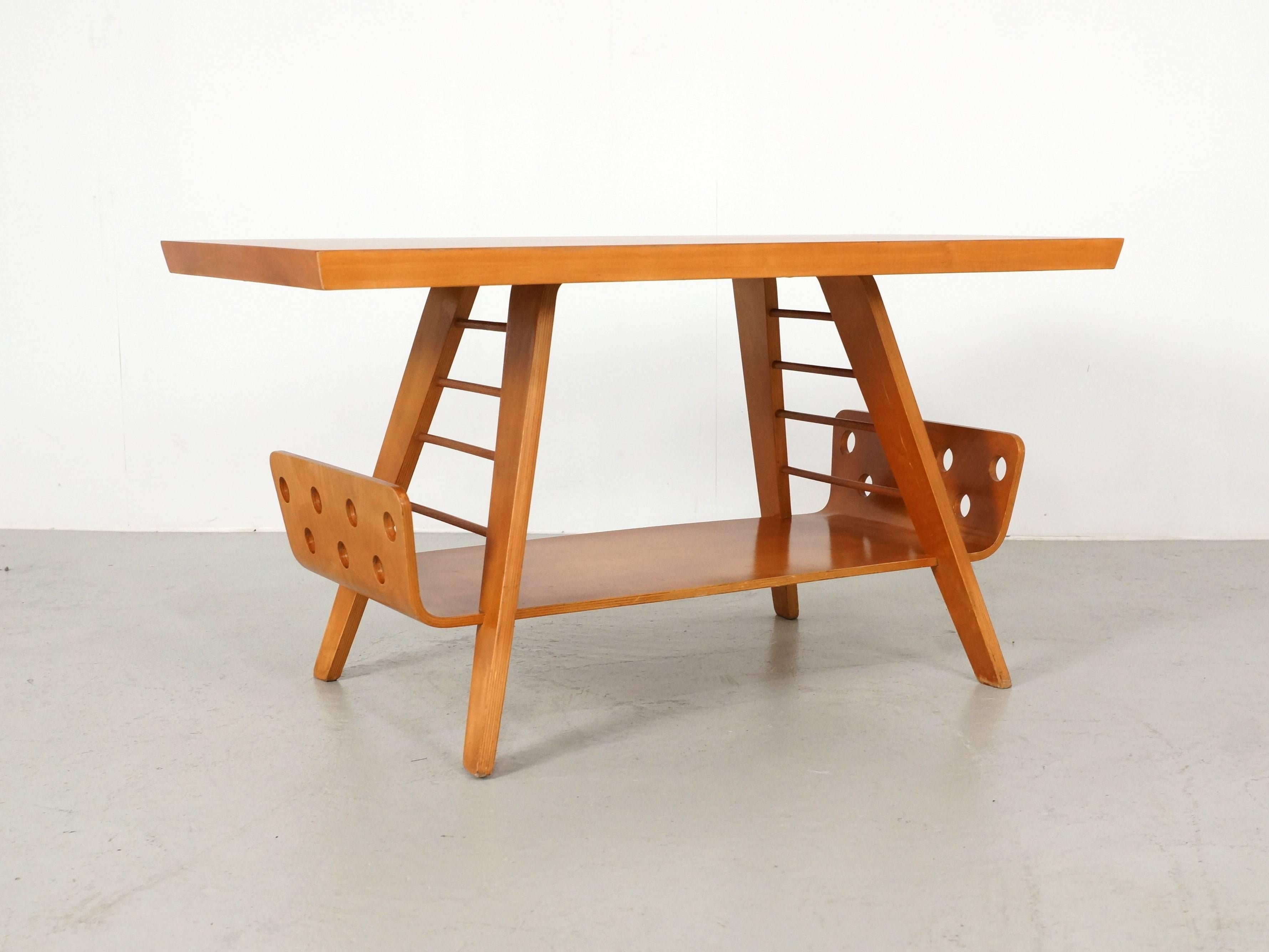 This bent plywood coffee table designed by Cor Alons for Gouda Den Boer is a beautiful Dutch design from the 1950s.
Veneered birch wooden tabletop with underneath a plywood shelve for your Magazines, with bent plywood legs. The bottom shelve has