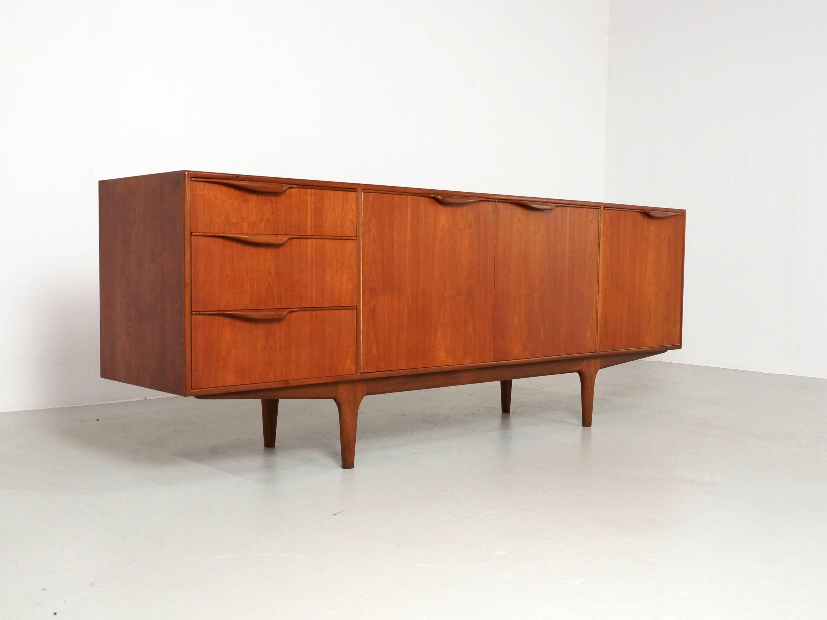 A beautifully designed and crafted teak 'Dunvegan' sideboard designed by Tom Robertson and manufactured by A.H. McIntosh of Kirkaldy, Scotland in the 1960s. 
This McIntosh sideboard in warm teak features beautiful carved handles which gives this