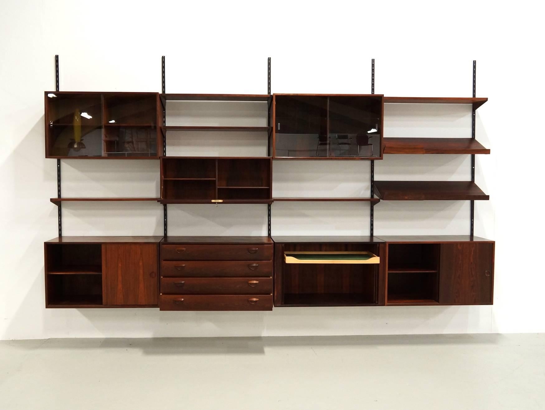 Exceptional large Wallsystem in Rio Rosewood Designed by Kai Kristiansen for Feldballes Møbelfabrik, 1960. This wall system has the next elements.
(bottom) two cabinets with sliding doors, one-drawer cabinet and one cabinet with tambour doors.