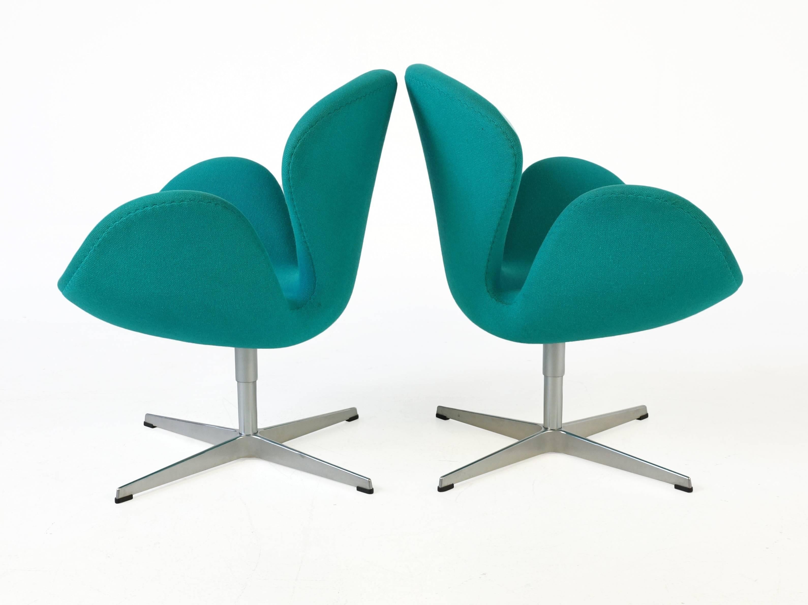 Pair of turquoise swan chairs from Arne Jacobsen for Fritz Hansen. The swan chair was designed by Arne Jacobsen in 1958 for the Royal Hotel in Copenhagen the organic curves is close to perfect. The swans have the original fabric in beautiful