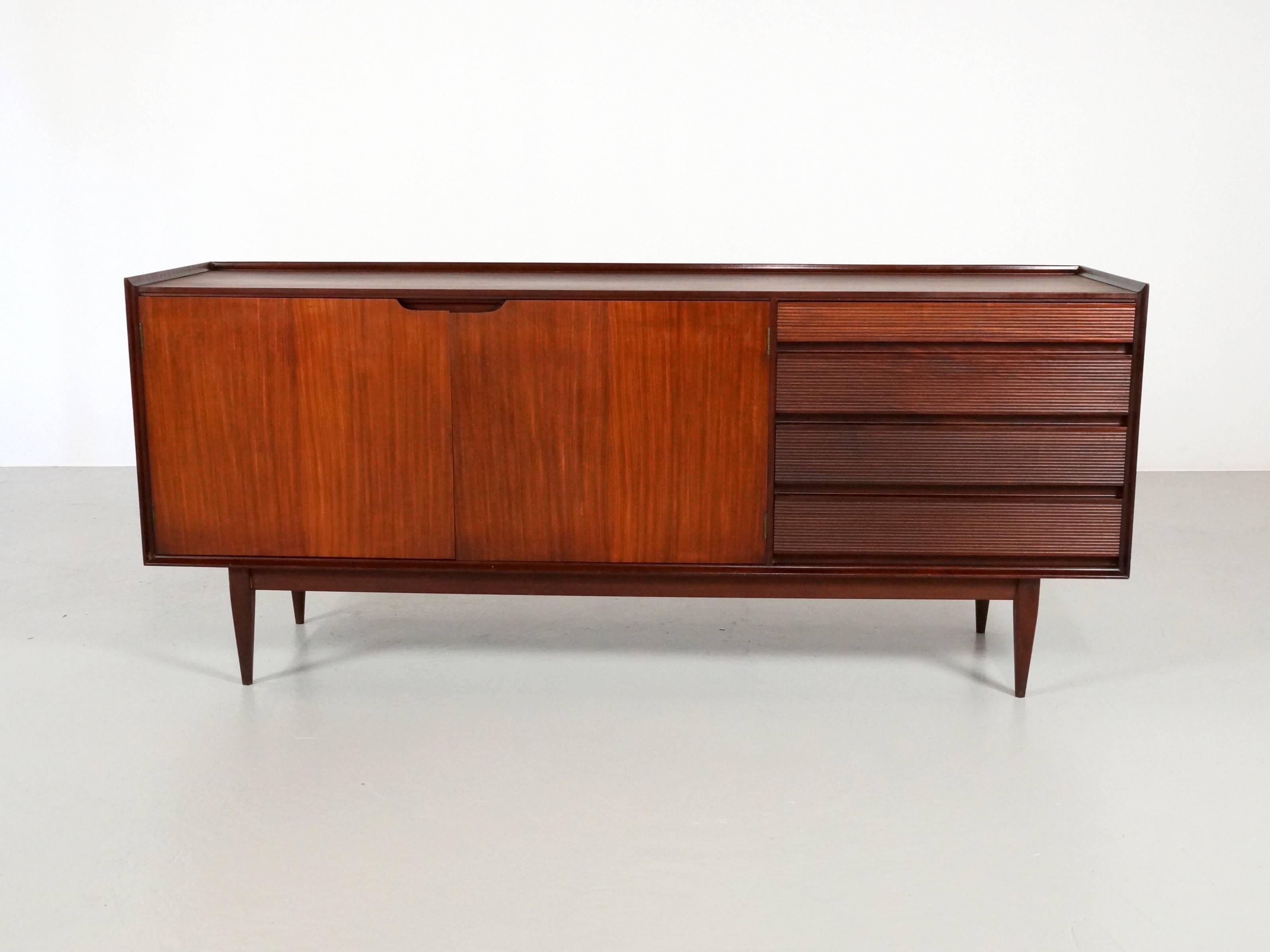 Stunning mid century sideboard designed by Richard Hornby and manufactured by Fyne Ladye furniture in the 1960s for sale in high end furniture stores such as Heals. 
It is made from solid Afromosia (no veneer) and is an exquisite example of British
