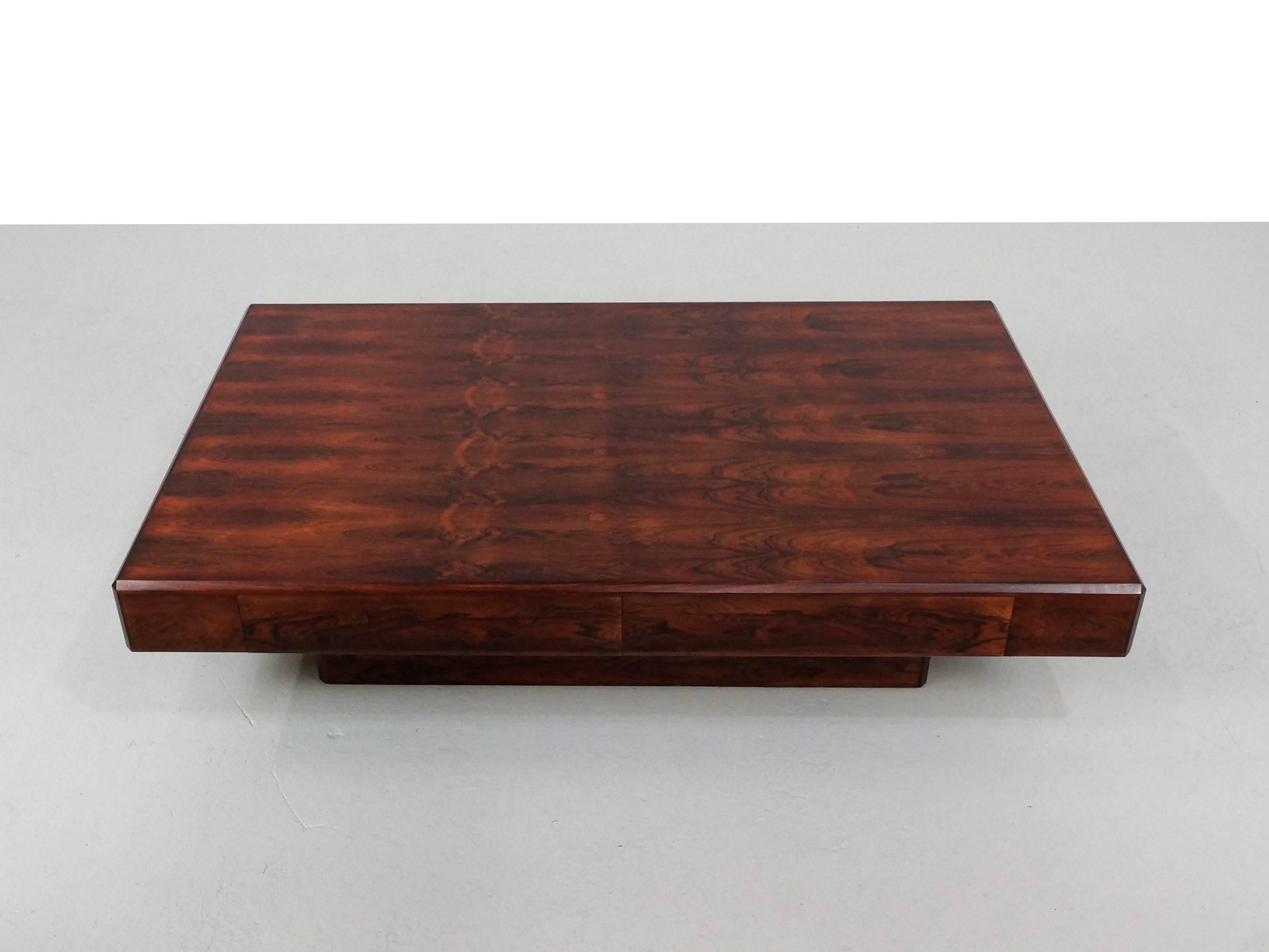 Low coffee table in high quality Rio Rosewood designed by Howard Keith for HK Furniture in the 1980s. The table stands on a pedestal base and has two blind drawers. This table is also known as the 