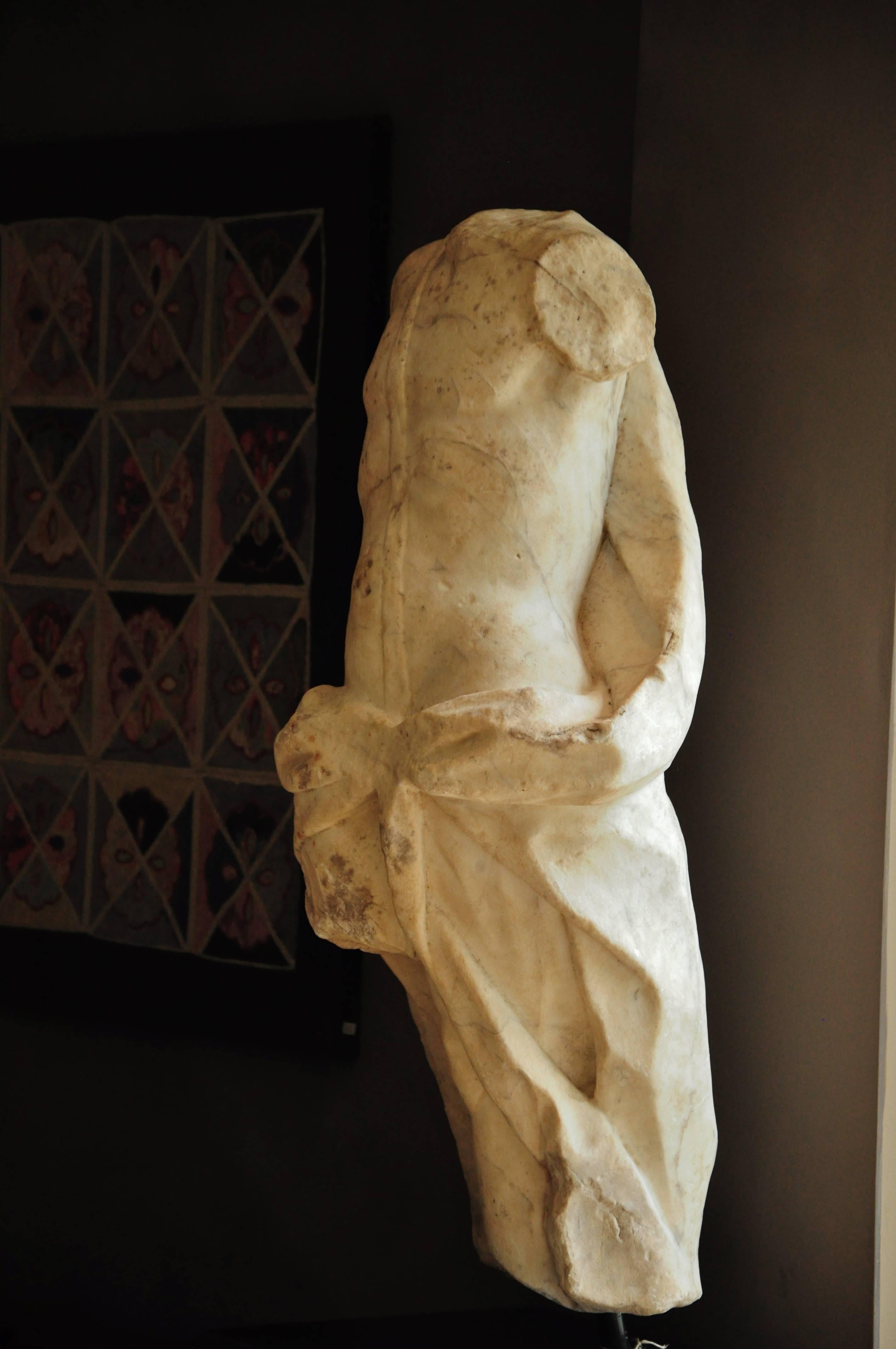 This marble torso was probably part of a larger sculpture group, possibly a late 18th century fountain. It represents a Apollo figure in Classical Roman style where the God is standing in Contraposto next to a tree and wearing a tunica and shoulder