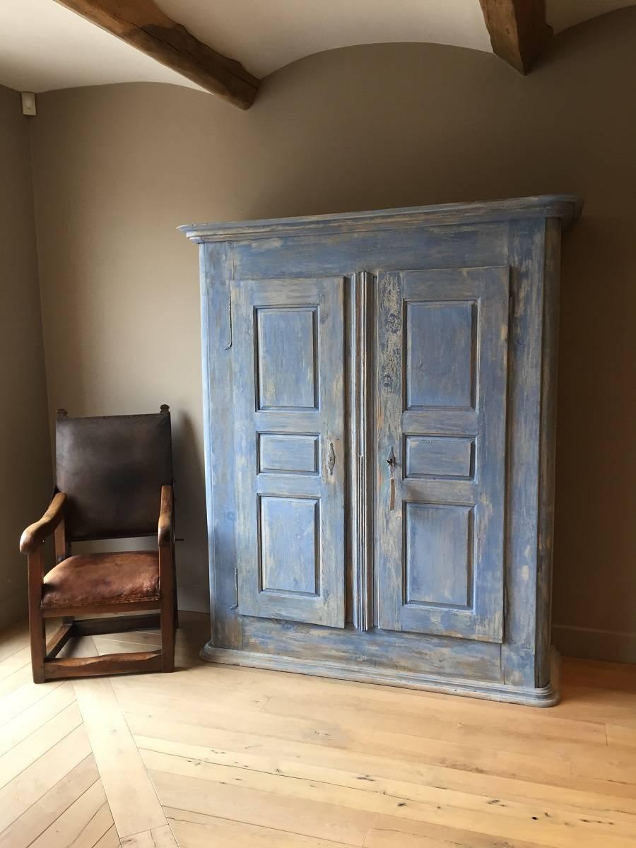 Late 18th century two-door cupboard with hidden compartment. This piece originates from the French Elzas region. It is manually constructed out of softwood which still holds it faded bleu organic paint. Apart from its great proportions it is rare