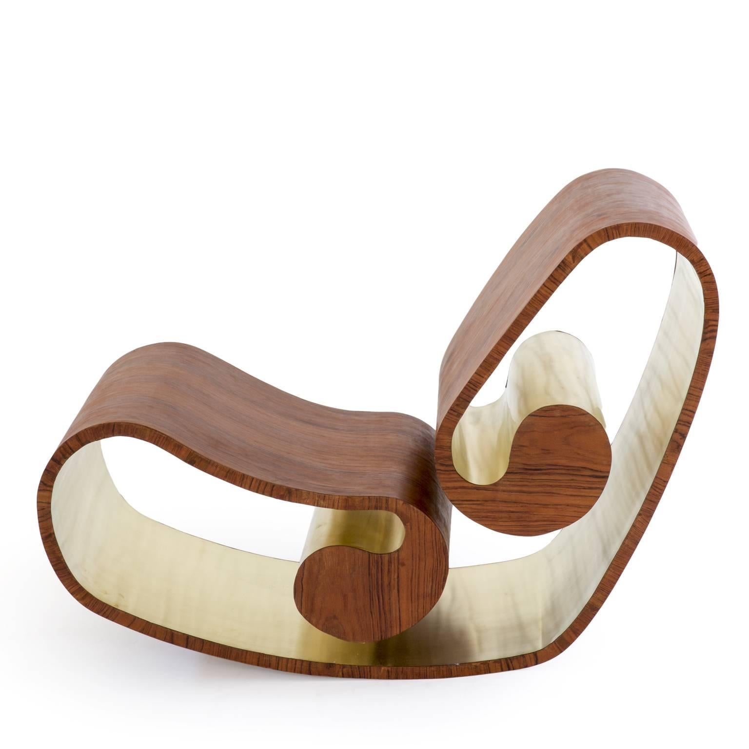The Voluta rocking chair, designed by Stefano Marolla, made of wood, carbon fiber and brass, is inspired to the classical organic plastic shapes, hiding behind its apparently simple structure, the complex technique needed to obtain the elastic