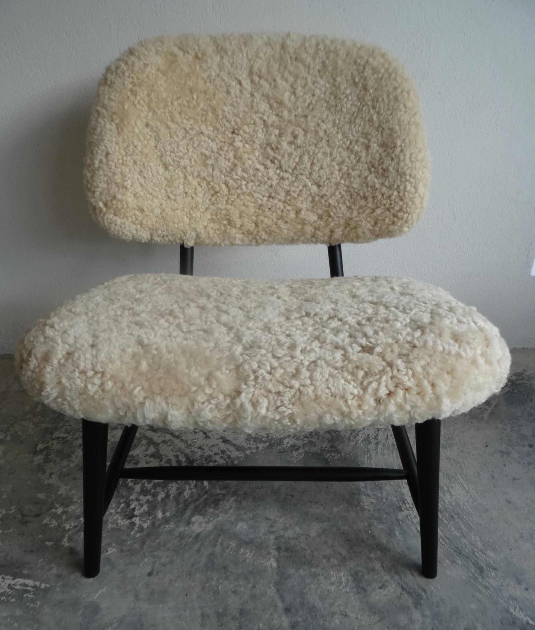 Two newly upholstered Te-Ve chairs. Initially designed by Alf Svensson for Ljungs Industries in 1953. These chairs have been given a modern look with sheepskin upholstery and a new black coat. A stylish chair with its brass fittings suitable in any