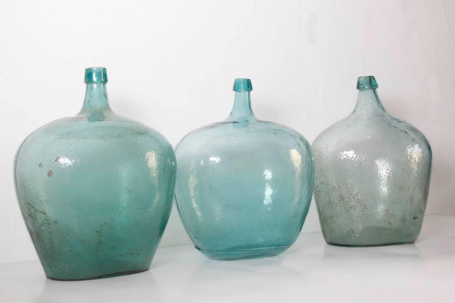 This set of three green handblow glass bottles or demijohns from the state of Oaxaca Mexico use to be used to store mezcal.
Sizes. The three of them are approximately same size.
Measures: 17 in H x 16 in W x 10 in D.