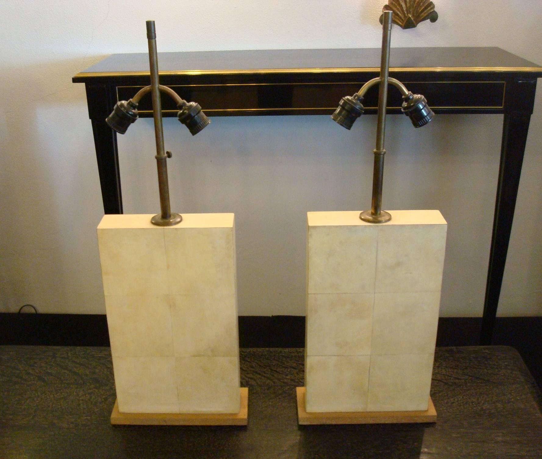 Lovely pair of parchment leather and oak table lamps. Jacques Adnet. Made in France, circa 1930. They have their original light fittings and cable, they can be replaced by new ones as request of the buyer. The overall height including the bronze