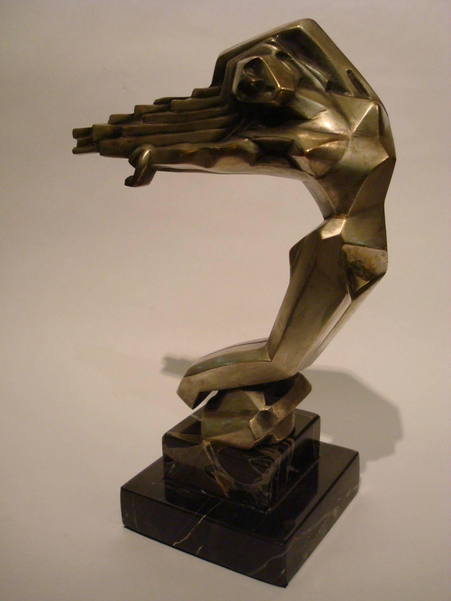 Art Deco Women on wind Car Mascot, hood ornament, France, 1930, D.I.M. Cubist.
Silver plated bronze mounted over a Portoro marble base.

Mascottes passion by Michel Legrand.
Fig 25: Cheveaux Au Vent - Stylise Art Deco.
This piece is typical of